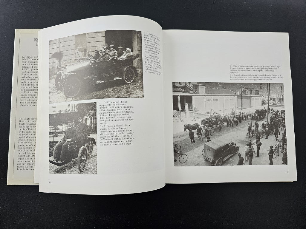 Photo history book open with multiple black-and-white car photographs and captions.