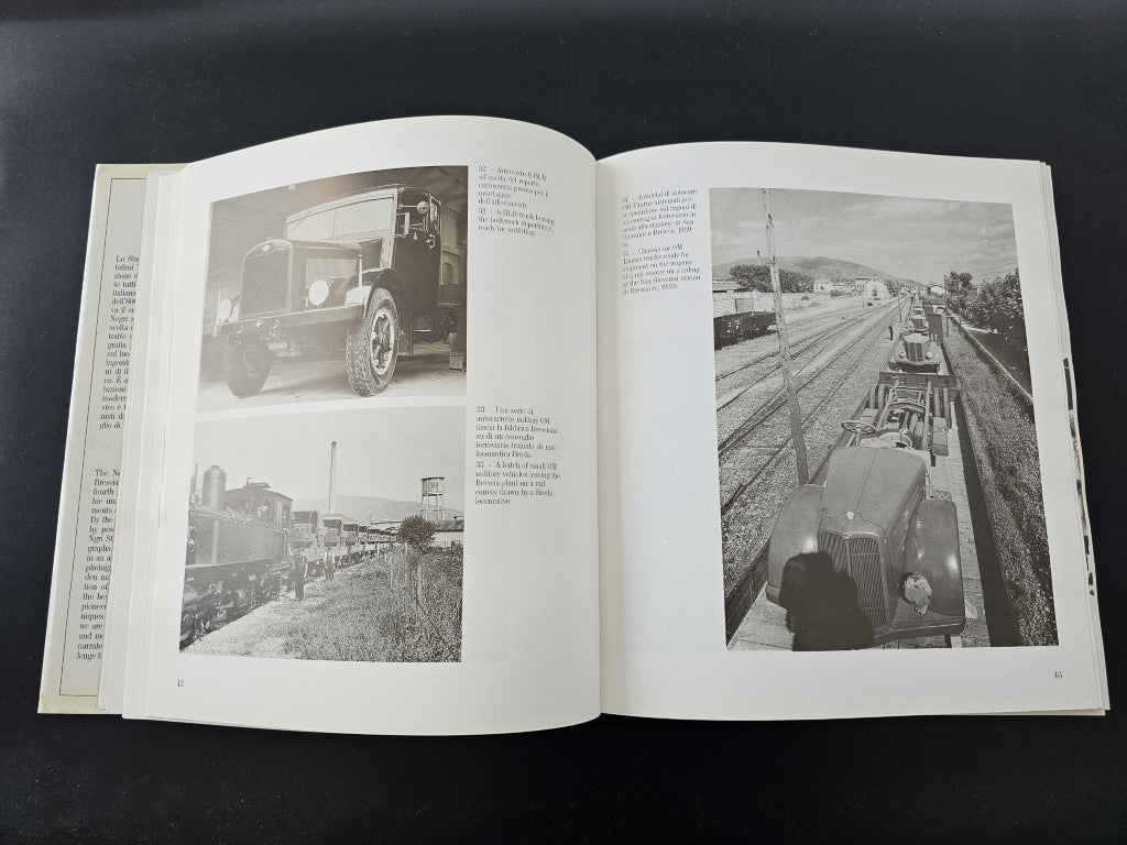 Photo history book open with two black-and-white workshop and vehicle photographs.
