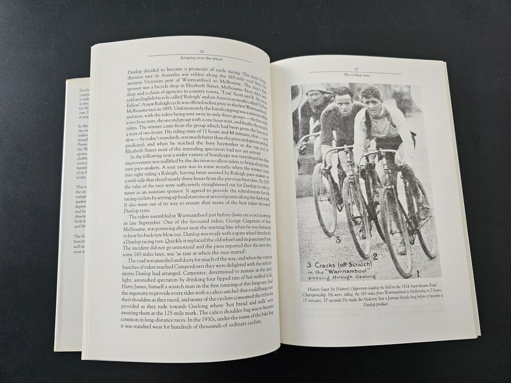 Book open with left text page and right page featuring a black-and-white cyclists photo