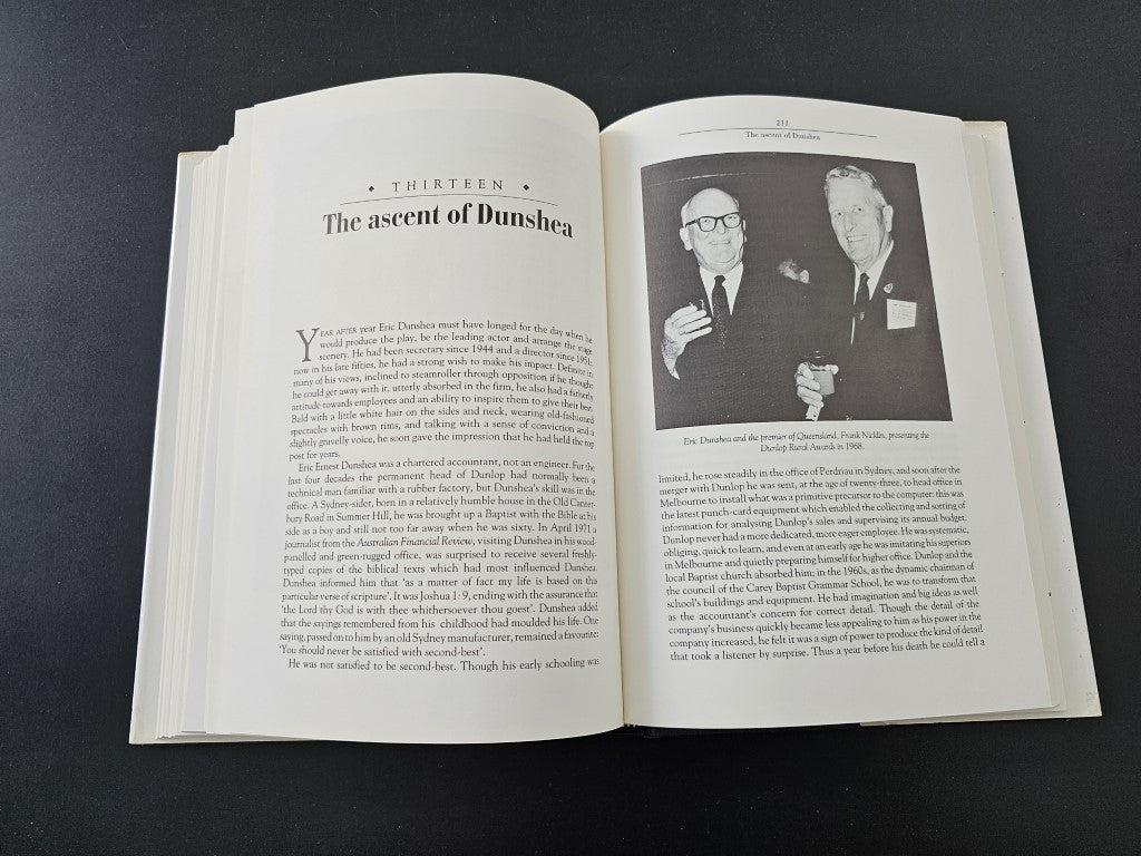 Open history book with printed text and two portrait photos on right page