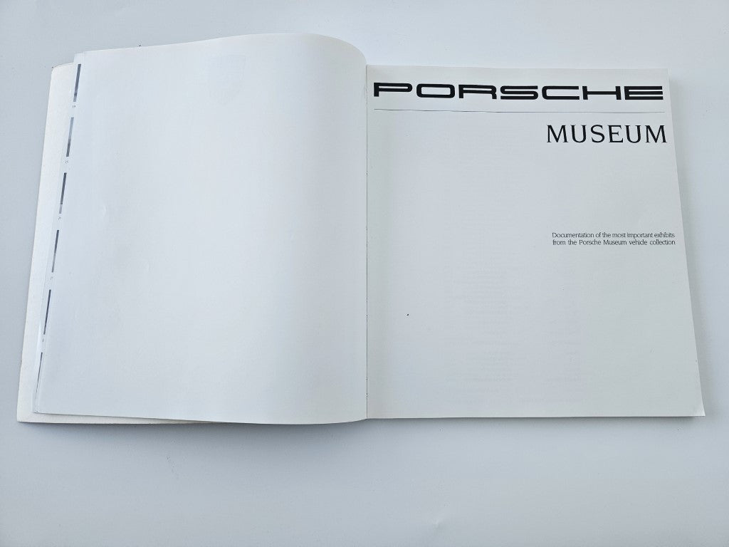 Hardcover book open to a page with Porsche Museum logo and blank interior