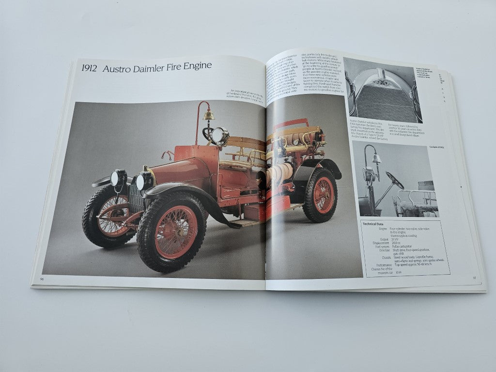 Hardcover book open to pages showing a red vintage car photo and technical text
