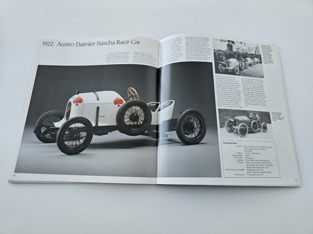 Hardcover book open to pages showing a white race car photo and diagram text