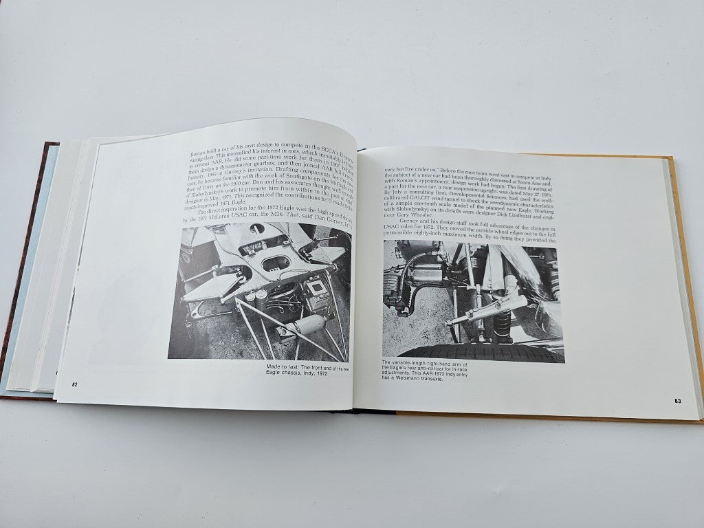 Open book pages with vintage black-and-white race car photos and printed text blocks.