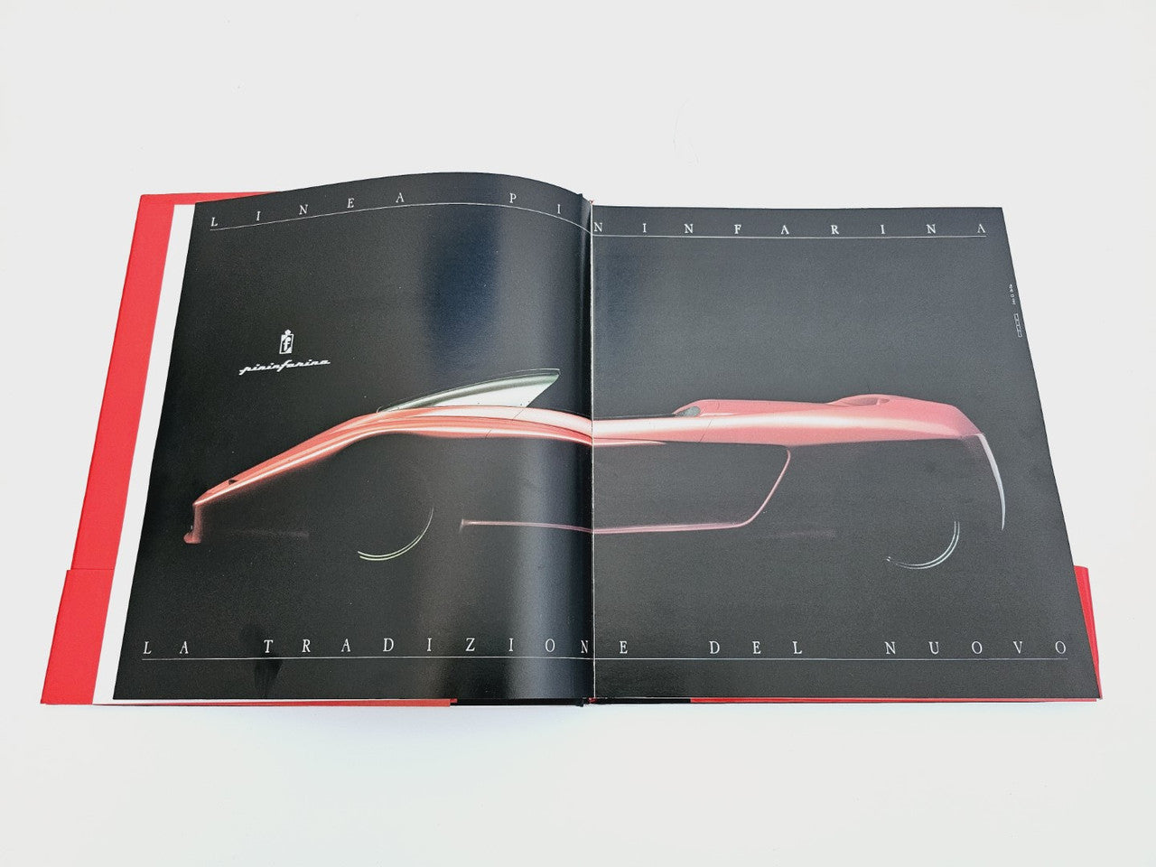 Open book with black spread and illustrated red vehicle silhouette diagram
