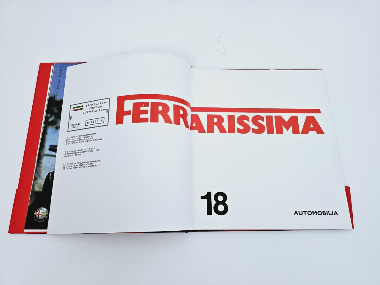 Open book page with Ferrarissima title, number 18, and Automobiiia text