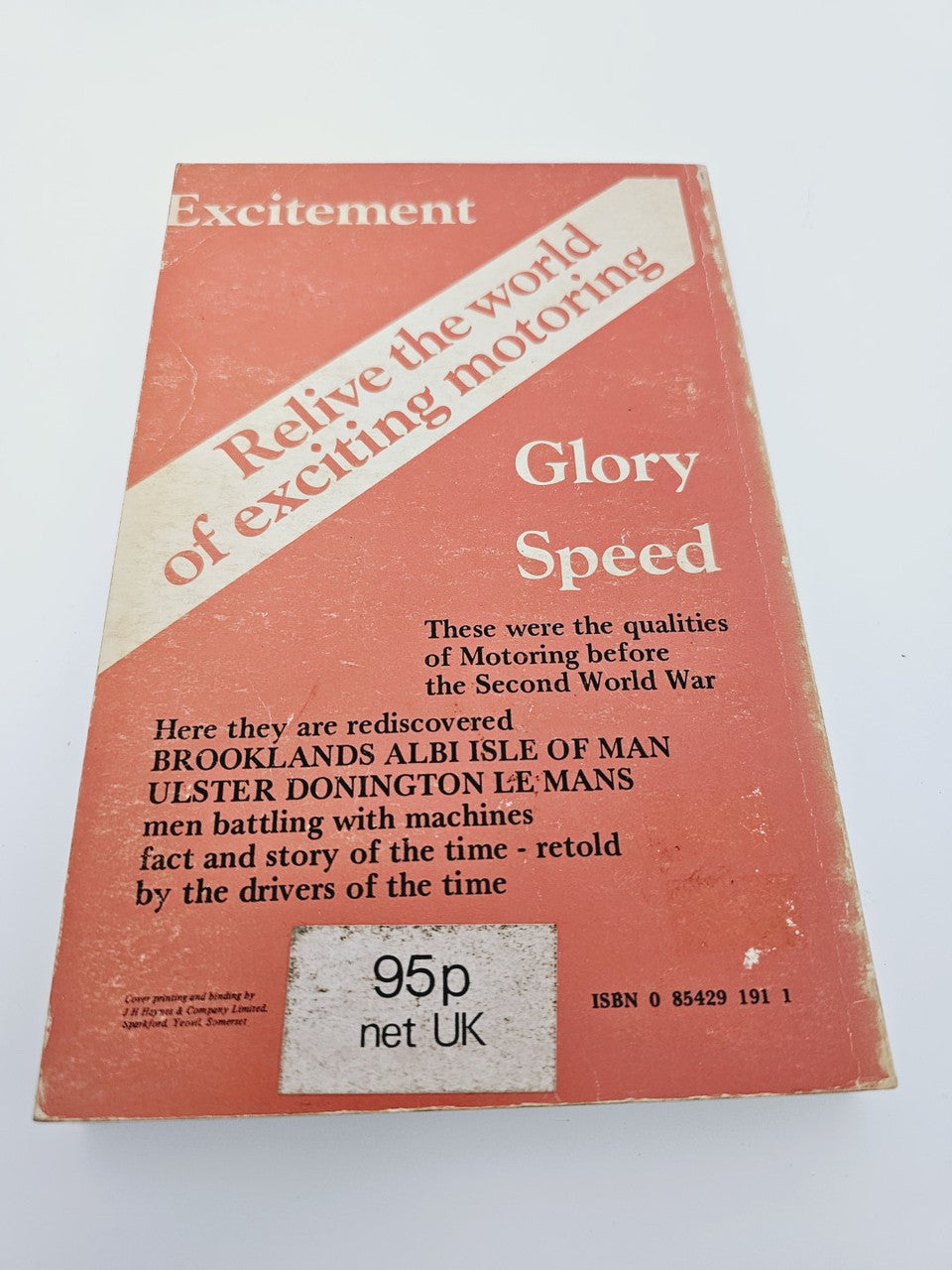Vintage red book cover with title text and car-themed graphic, plus price details