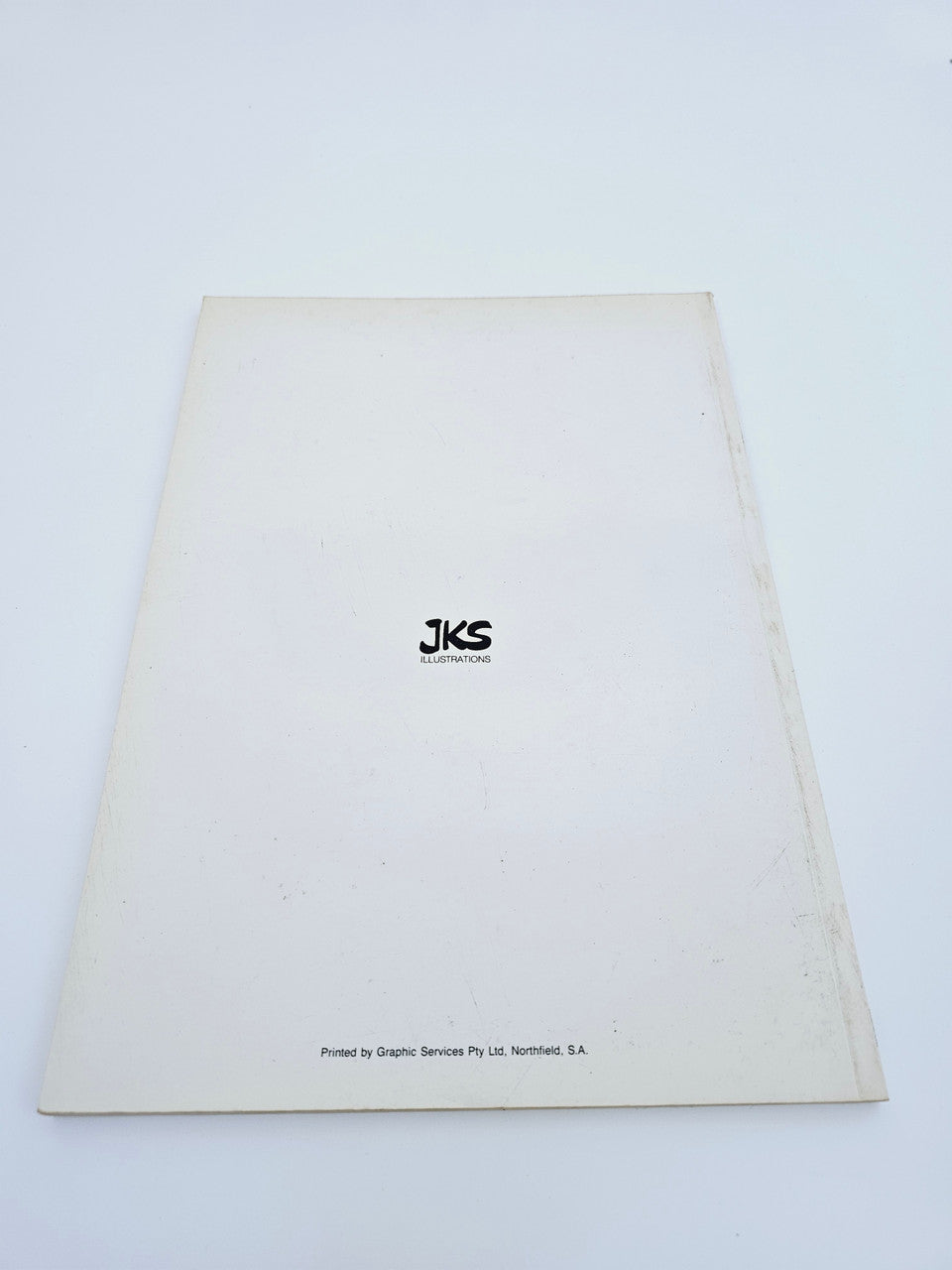 Signed cartoon collection book, plain white back cover with JKS International mark