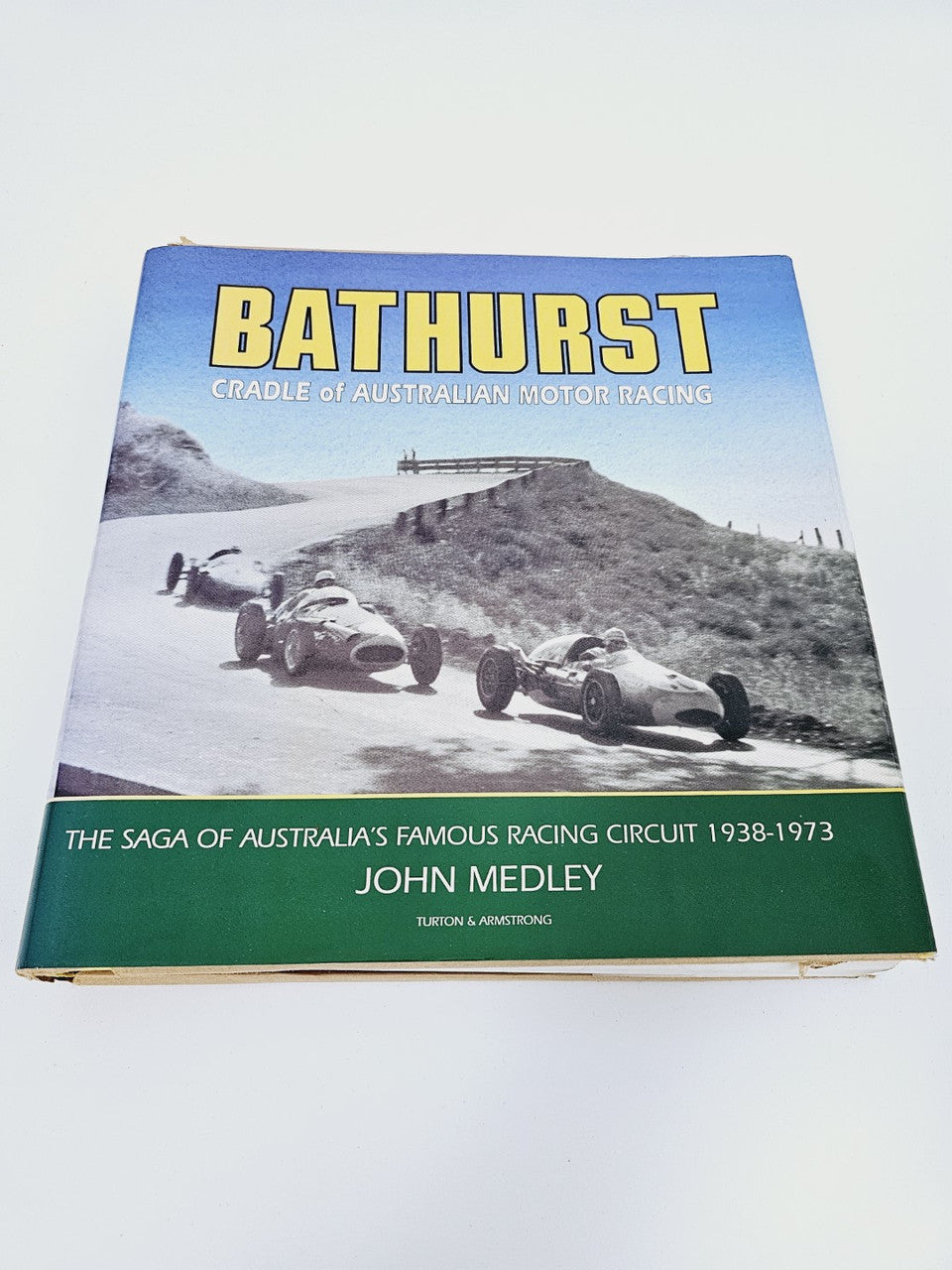 Signed racing history book with blue cover and Bathurst car action photo