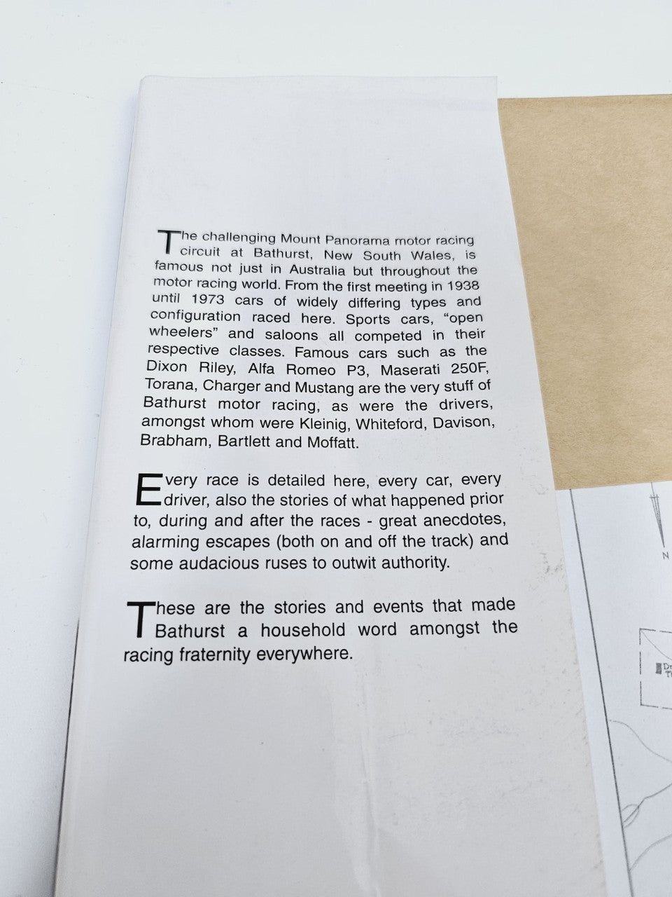 Open book page with printed racing text and paragraphs in black ink