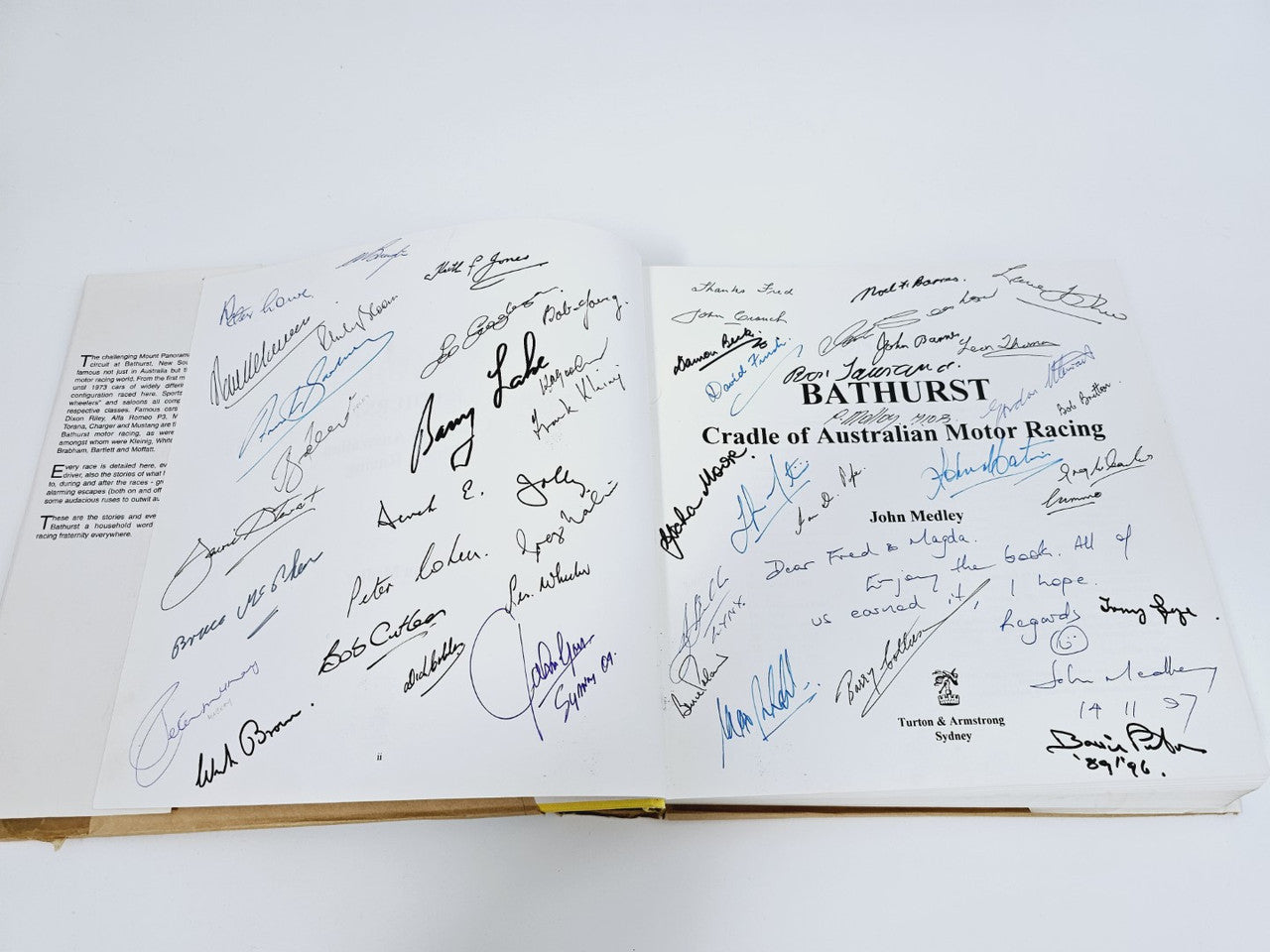 Open book page with many blue marker signatures on white paper