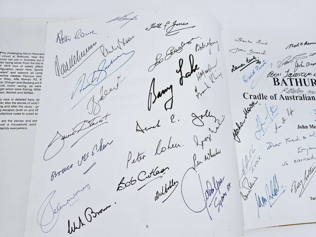 Open book page with bold black and blue autograph signatures