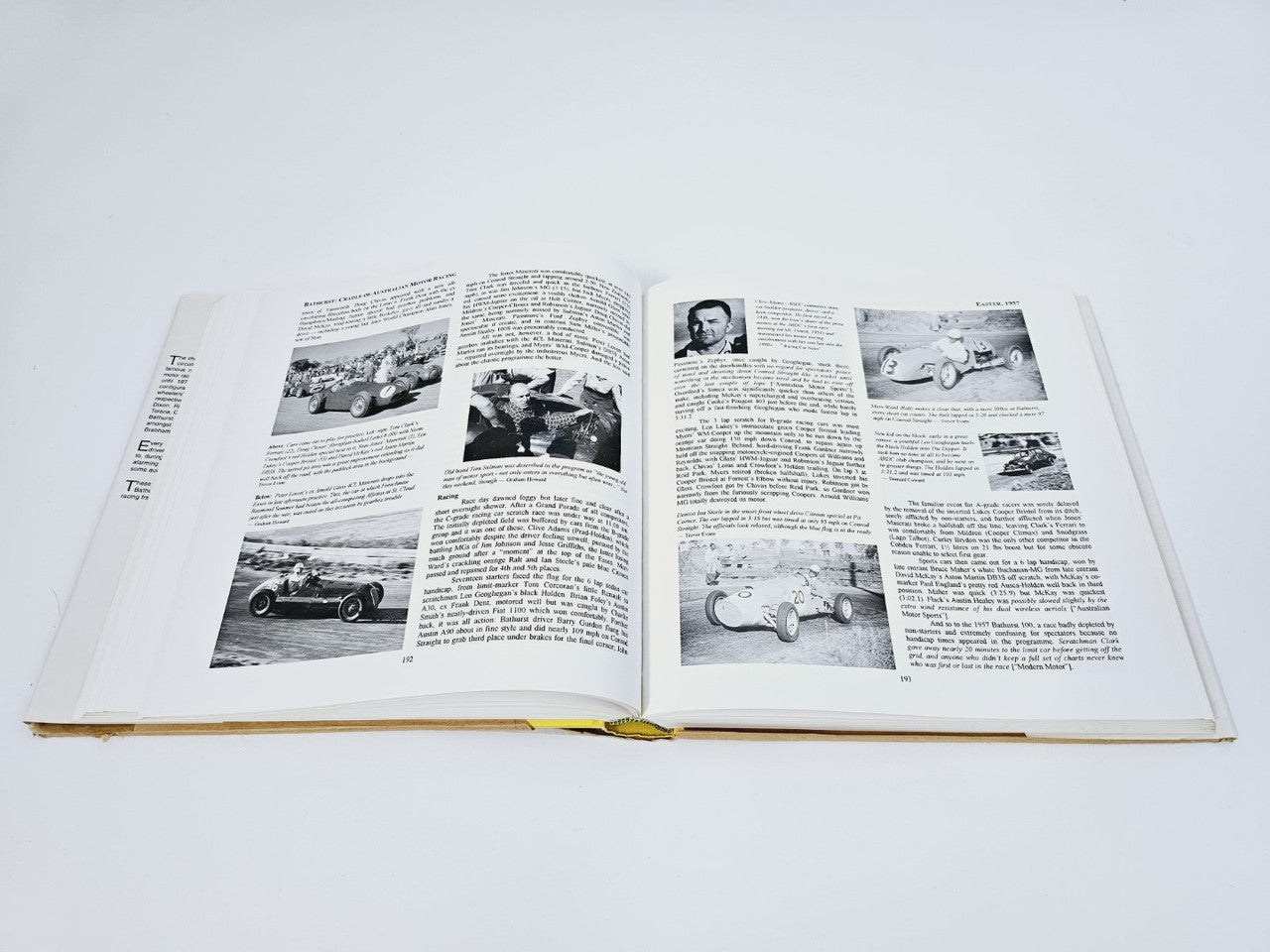 Open hardcover book with black-and-white racing photos and dense text pages