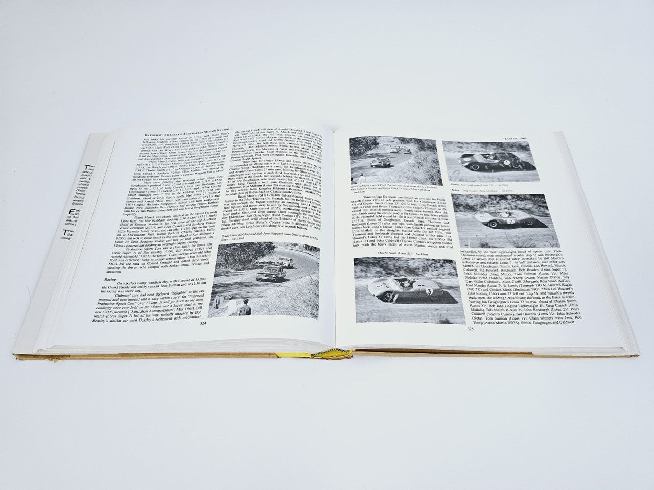 Open book with two columns of text and several black-and-white car photo inserts