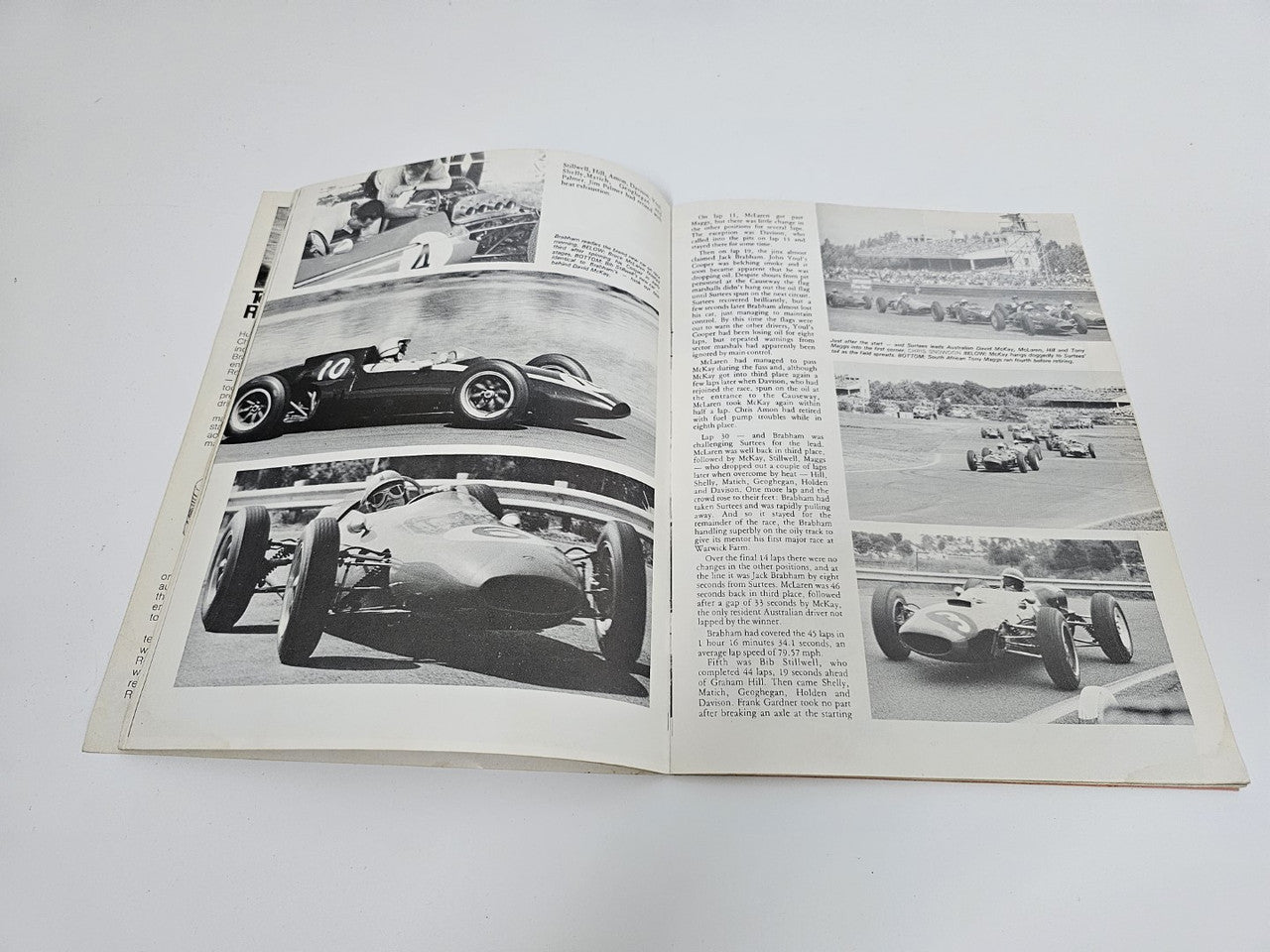 Vintage motorsport magazine open to black-and-white race car photo pages