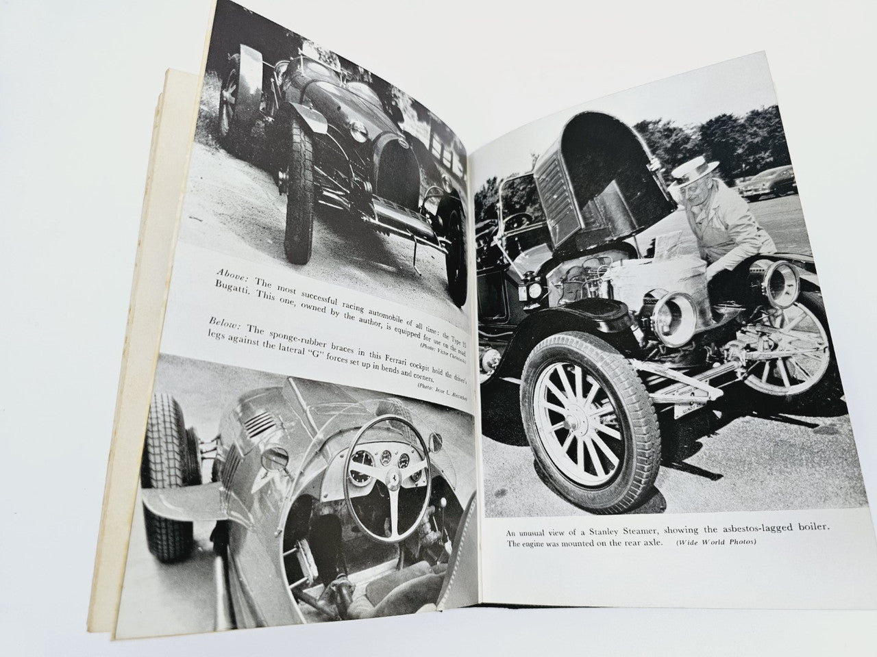 Opened automobile book with black-and-white photos of vintage cars and wheels.