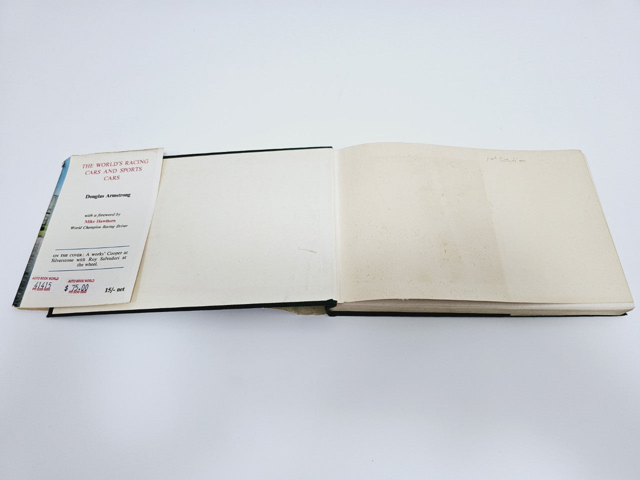 Open vintage racing cars book with illustrated title page and blank inner page