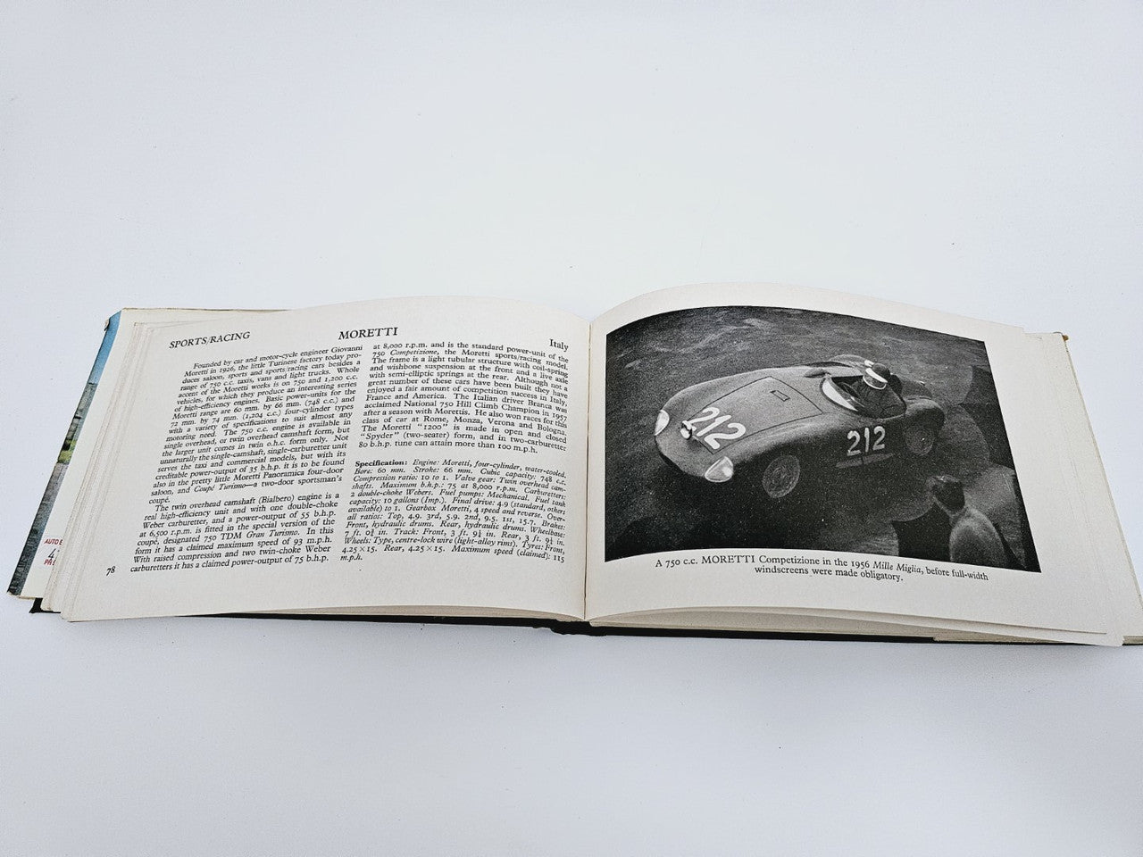 Open book with sports car feature text on the left and a black-and-white car photo