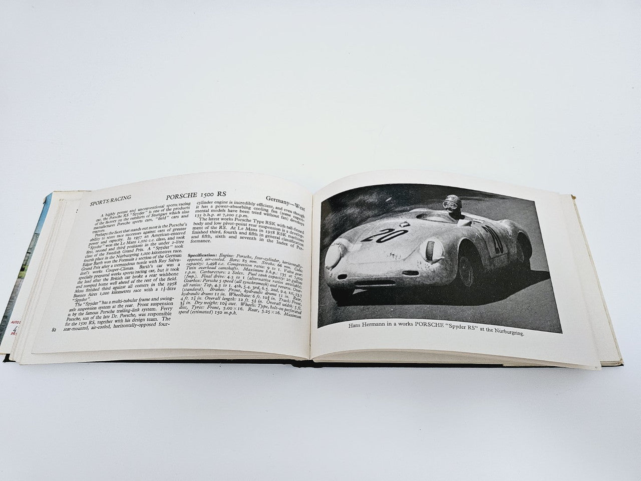 Open vintage racing cars book spread with text and black-and-white car portrait photo
