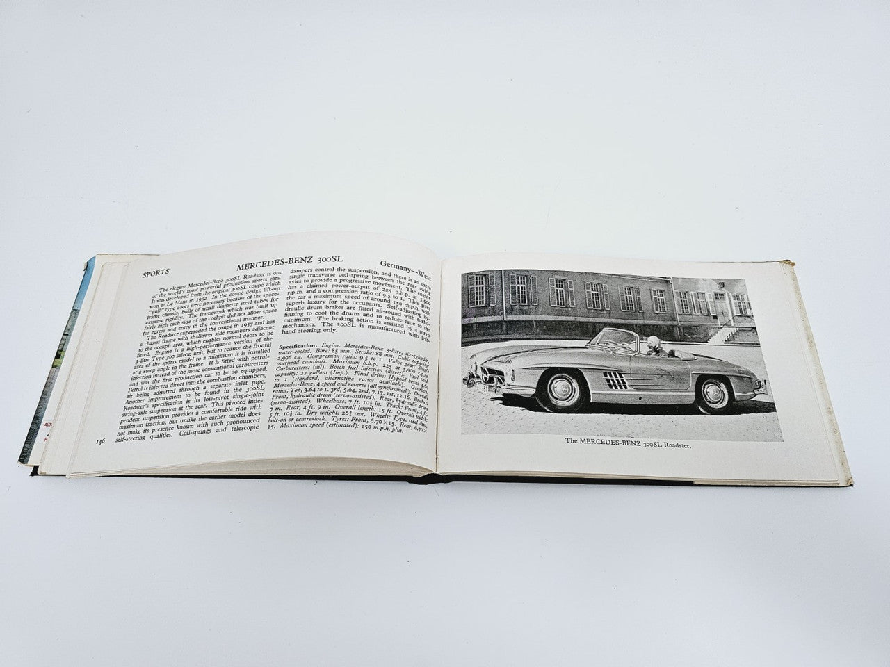 Open book showing printed text on the left and a classic car photo on the right