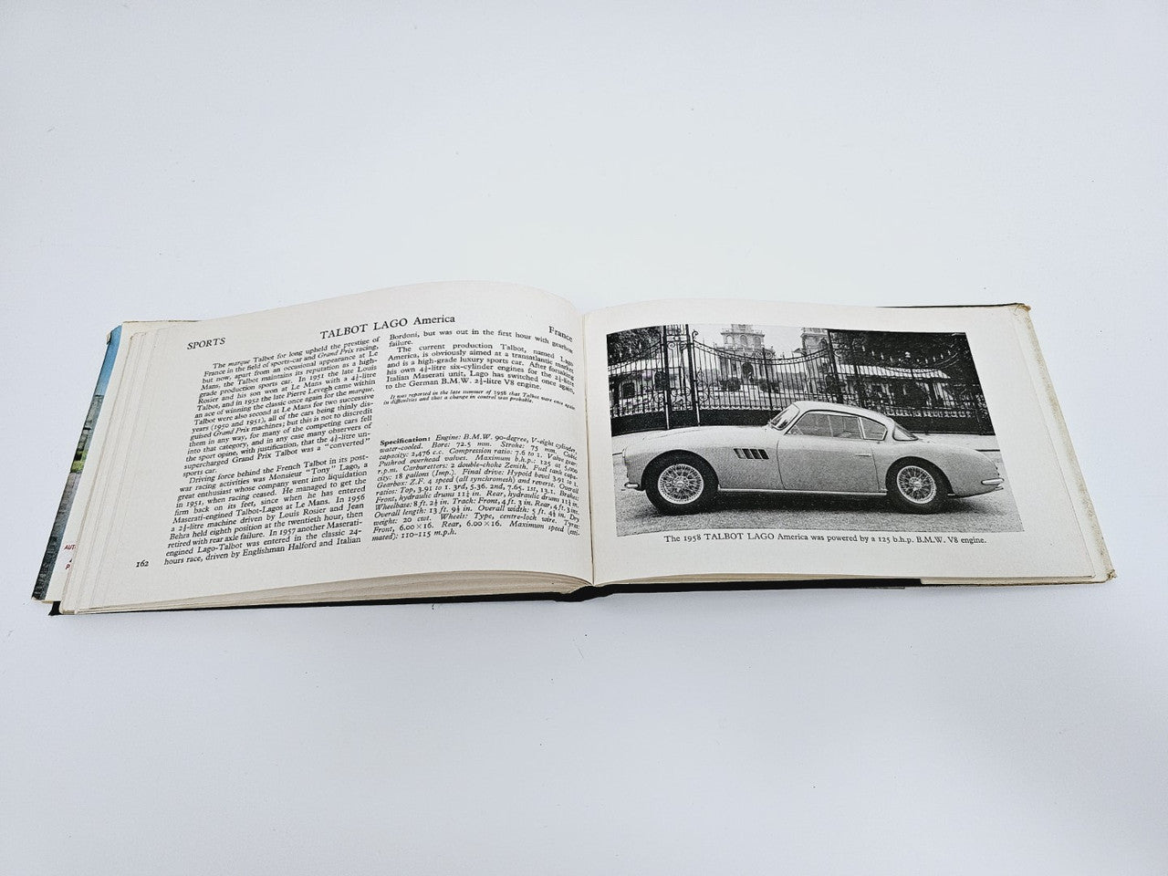 Open vintage racing cars book with race text section and color sports car photo