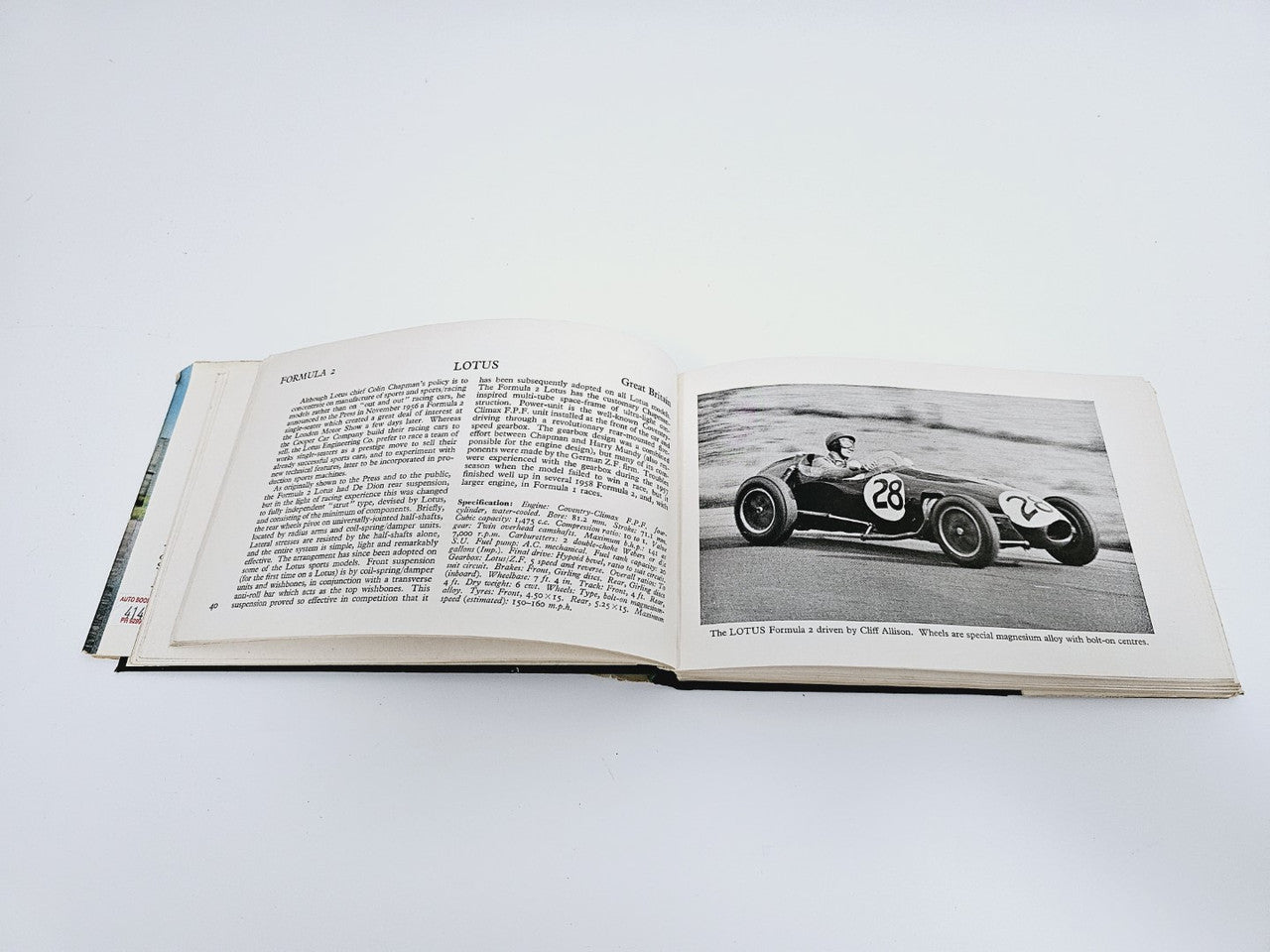 Open vintage racing cars book with black-and-white race car photo and text pages