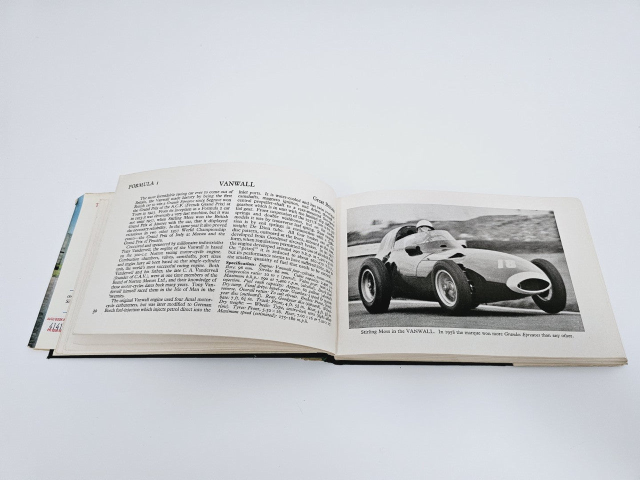 Open vintage racing cars book spread with car photo, caption text, and paragraphs
