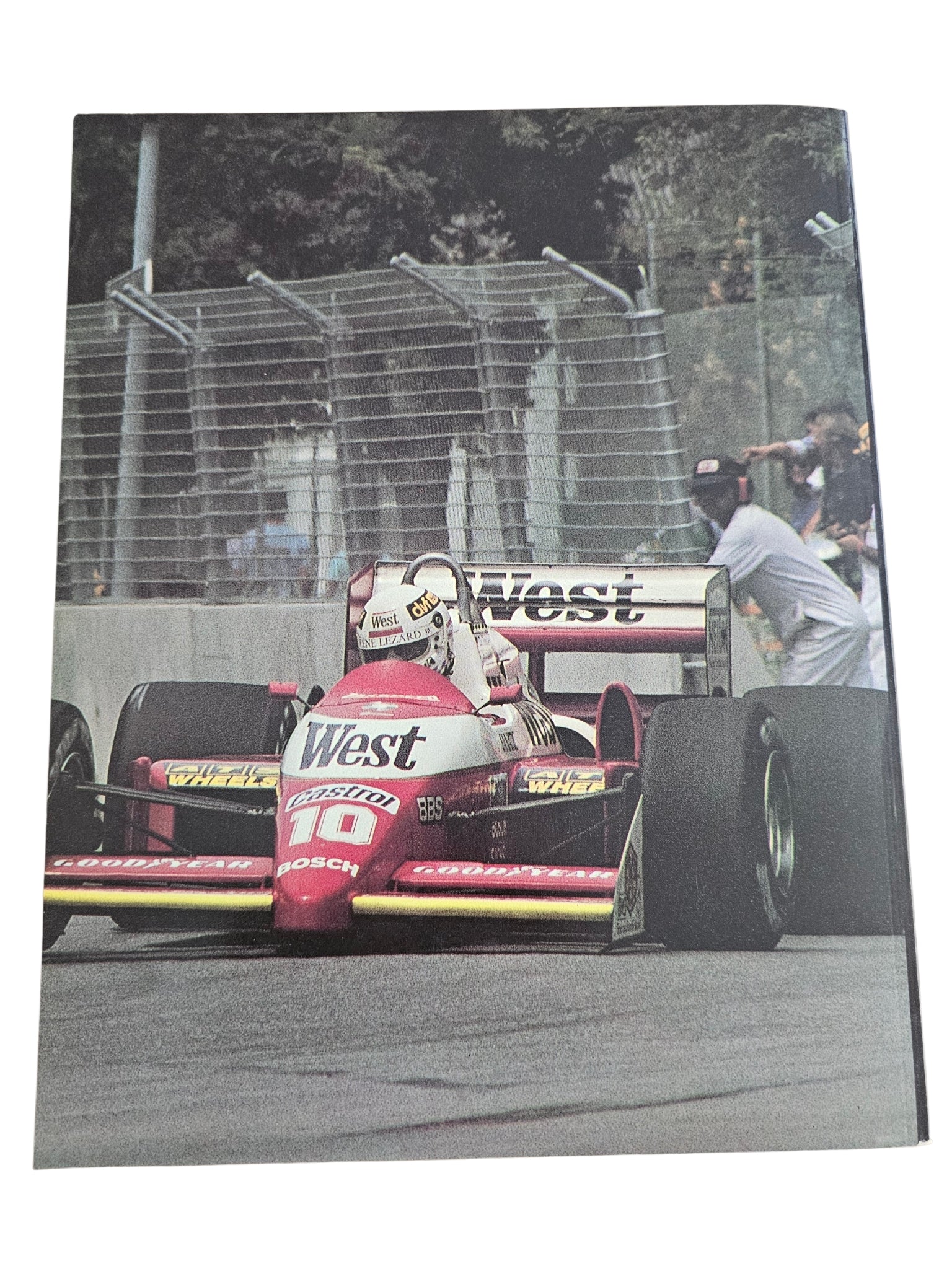 Motorsport action book page with pink race car and driver at track fence
