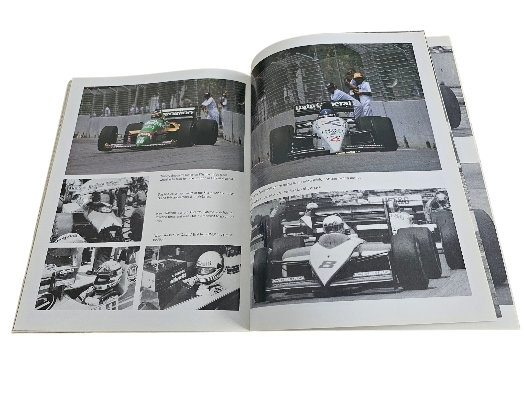 Open motorsport action book with two-page spread of race car close-up and track images