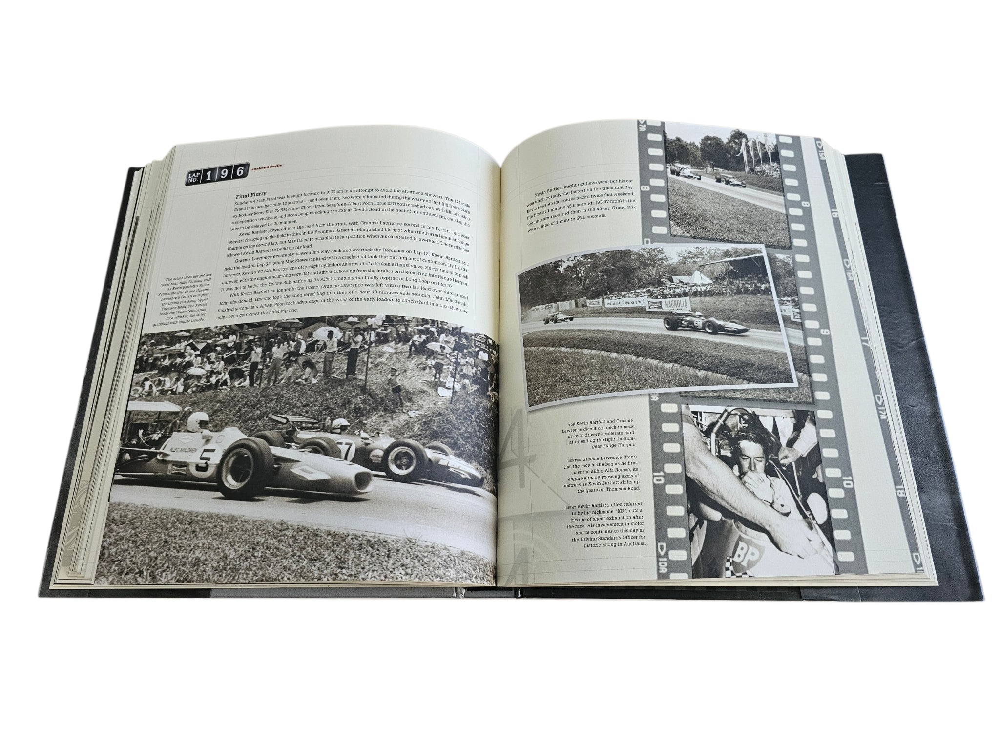 Signed Singapore Grand Prix history book, open to large crowd and track race photos