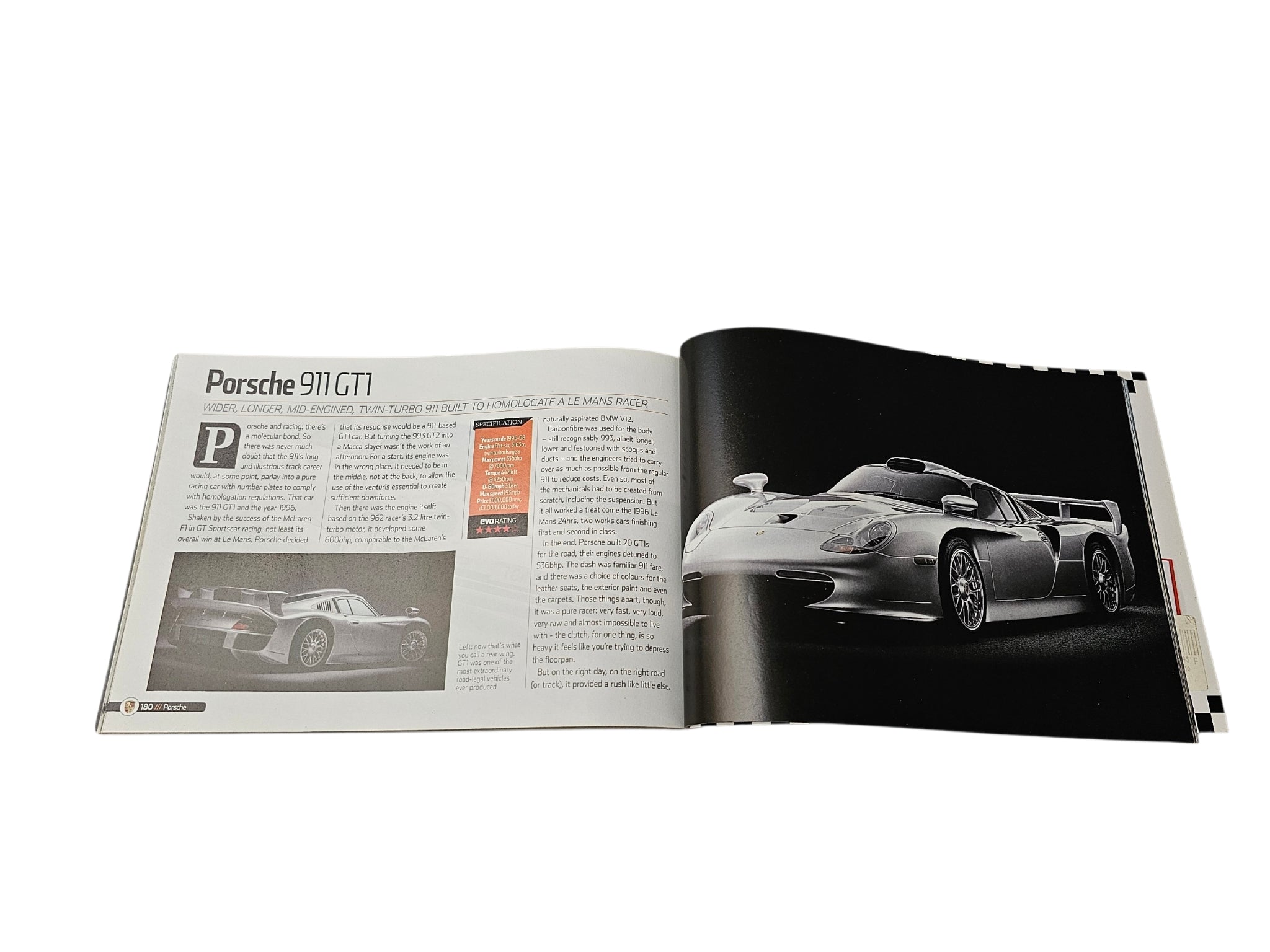 Supercar guide book open spread with Porsche 911 GT1 page and dark background photo
