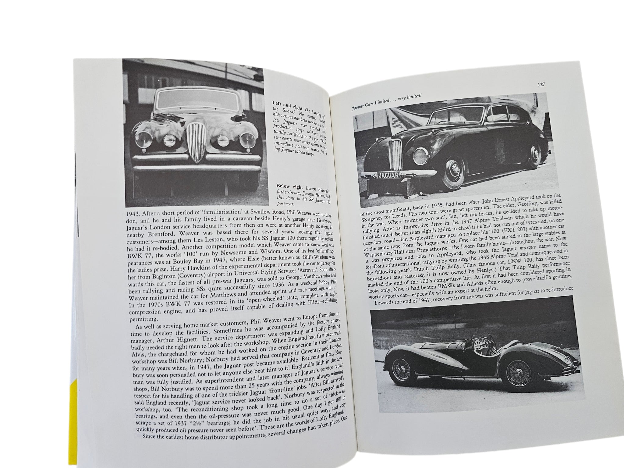 Open car history book with black-and-white vintage Jaguar car photos and captions