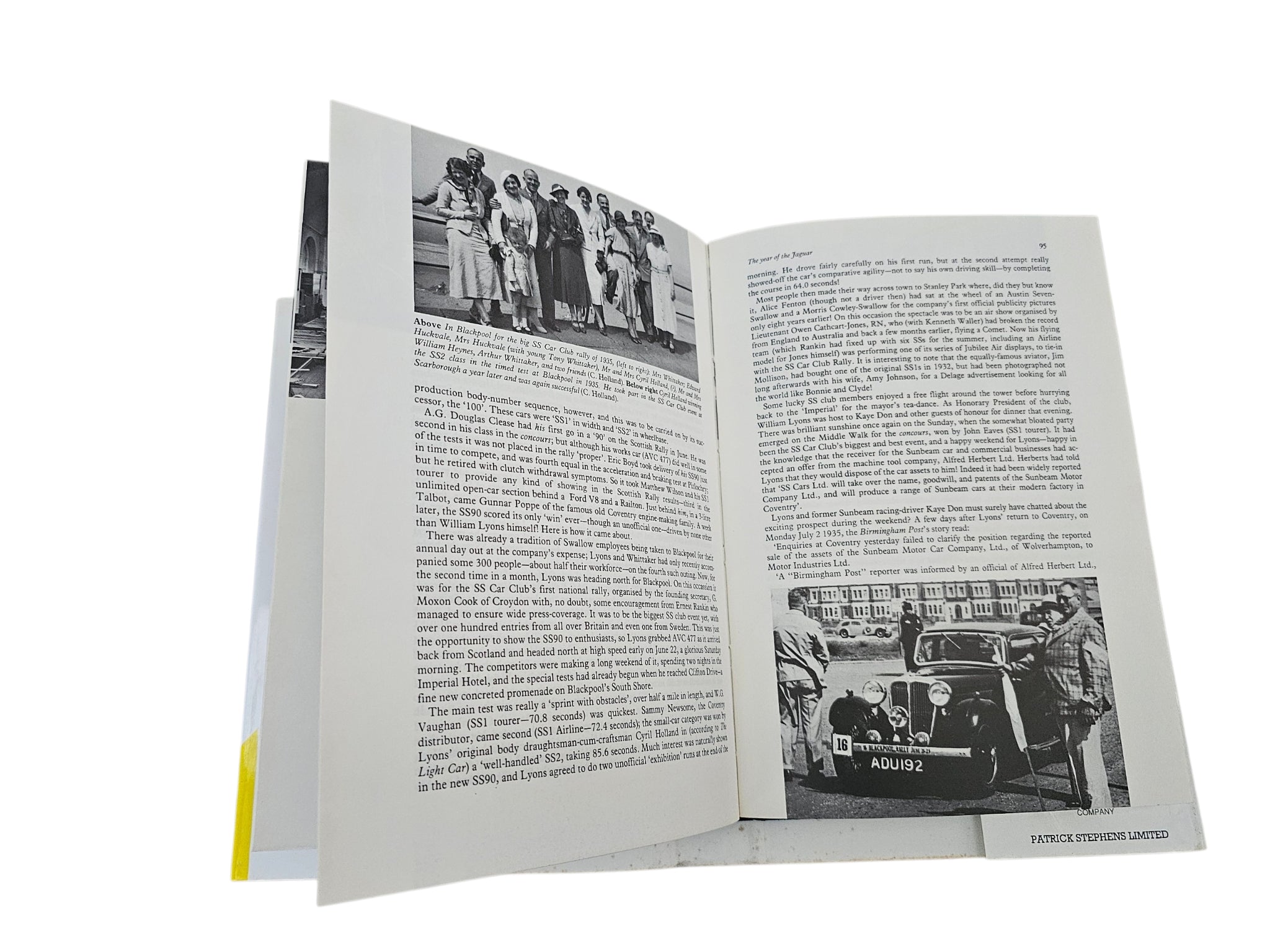 Open car history book with vintage group photos and dense captioned text