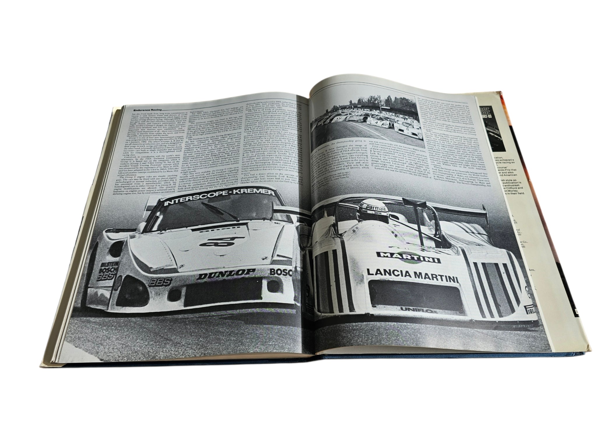 Open hardcover motorsport book with black-and-white race car photo pages