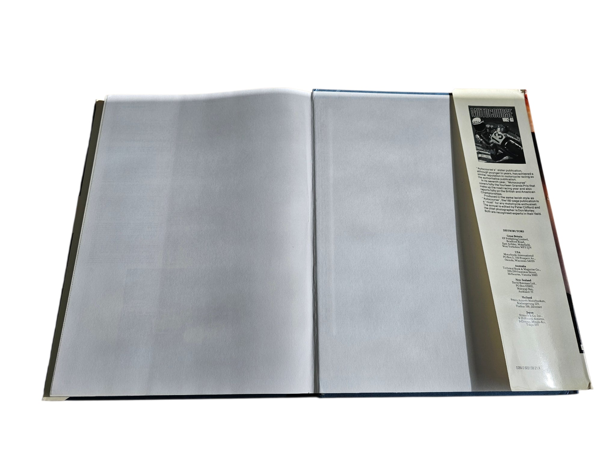 Open hardcover book with two blank-looking inner pages and side insert