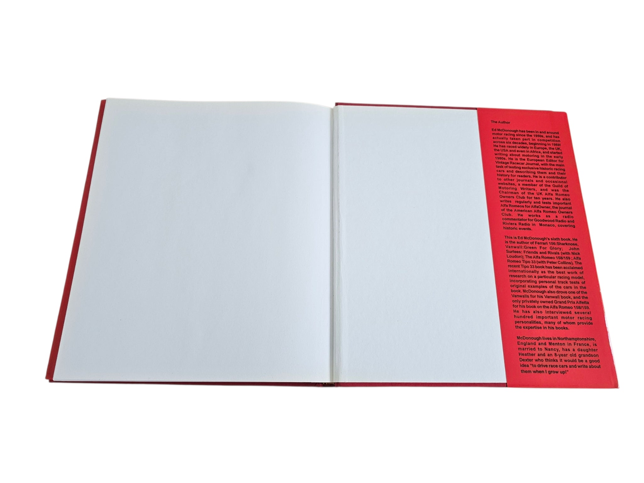 Signed hardcover book opened to blank pages with red text block on the side
