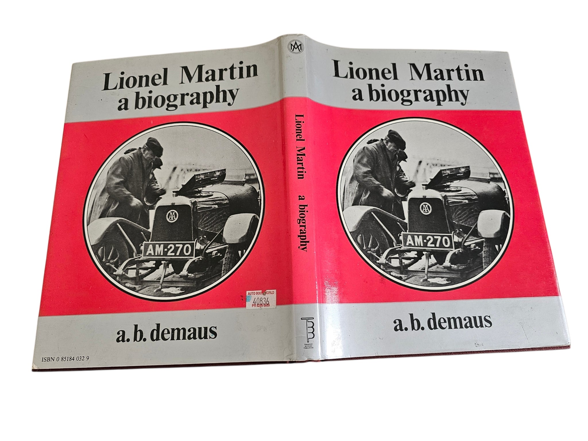 Hardcover biography book, two-copy view with red spine and circular car photo on covers