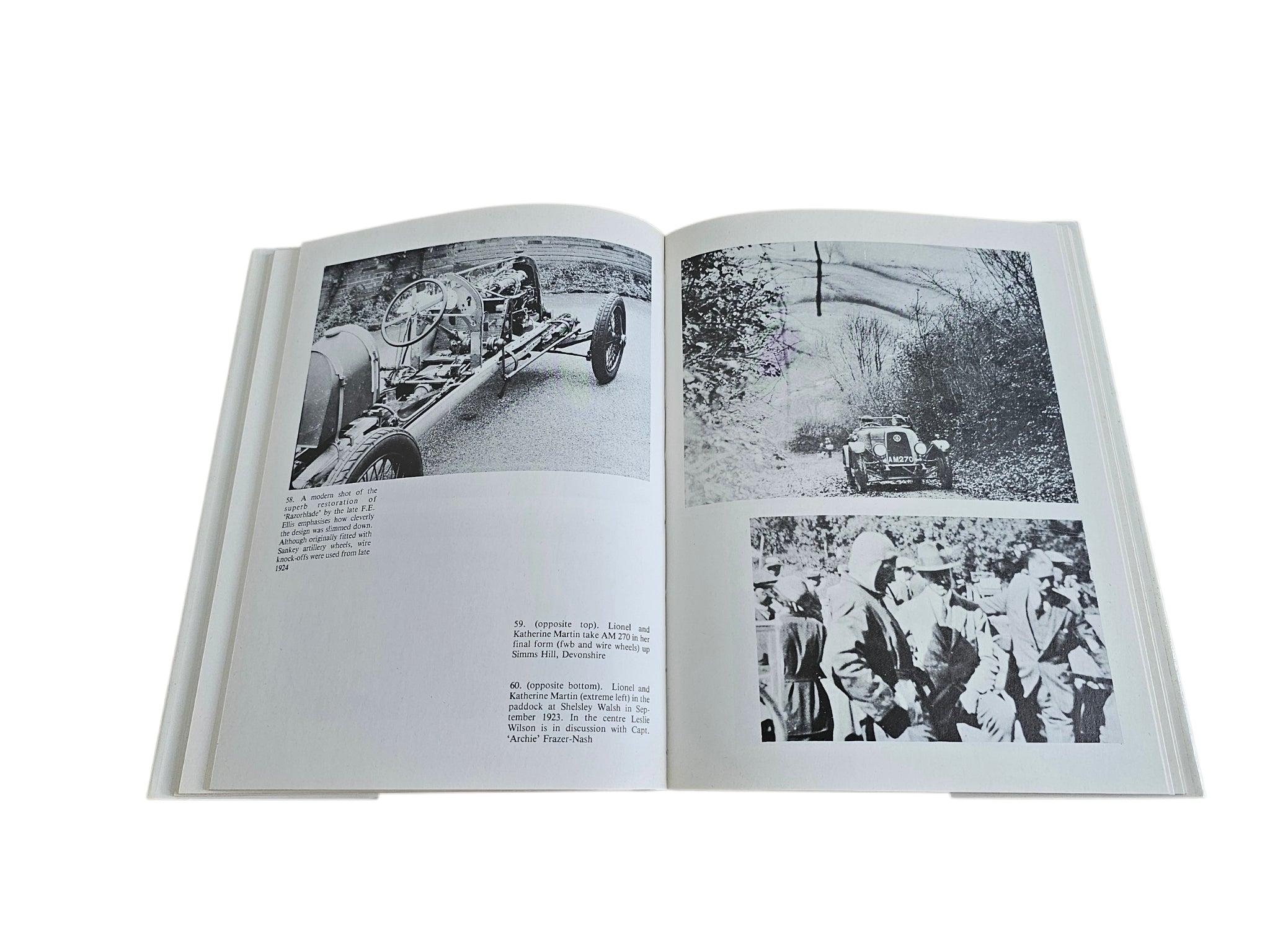 Hardcover biography book open to black-and-white photo pages with vehicles and a crowd