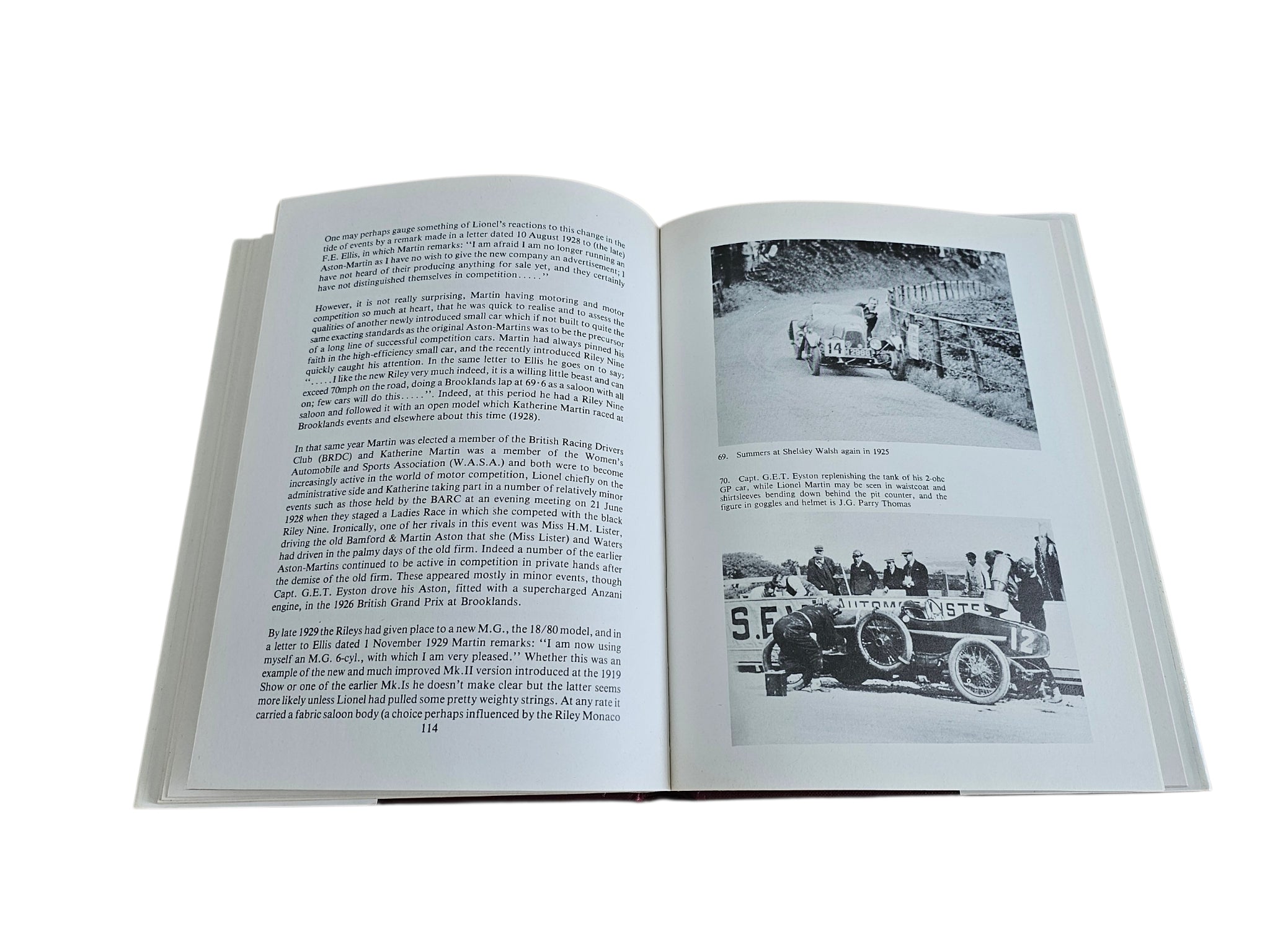 Hardcover biography book open to black-and-white photo pages with cars and an event scene