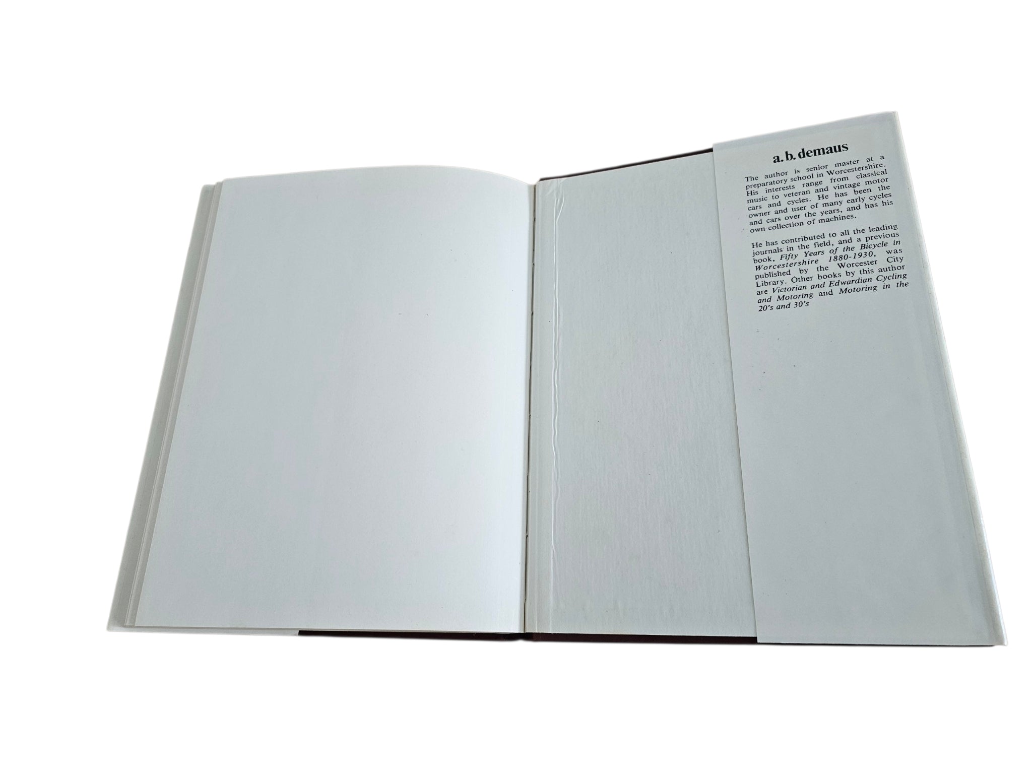 Hardcover biography book open, mostly blank pages with small printed text near the top