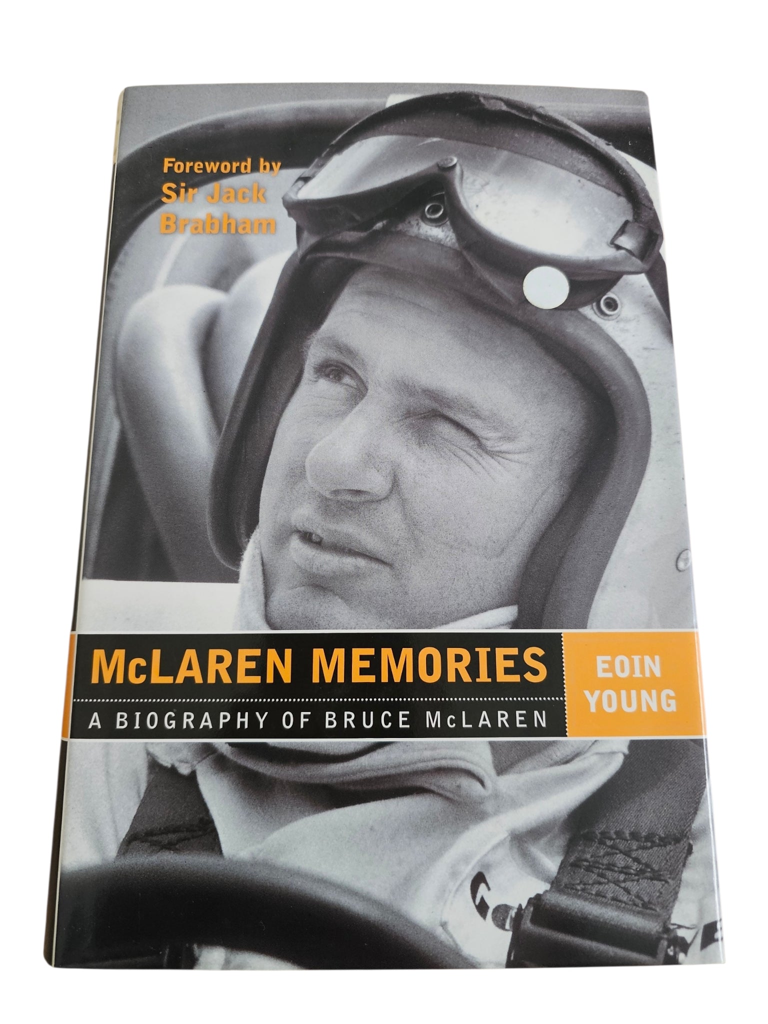 Signed motorsport biography book, helmeted driver portrait on cover with author band