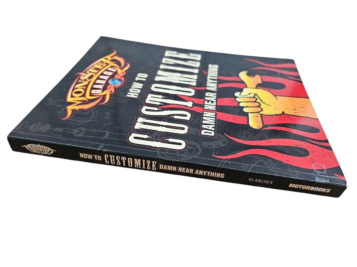Book titled 'How to Customize Damn Near Anything' on a wooden surface