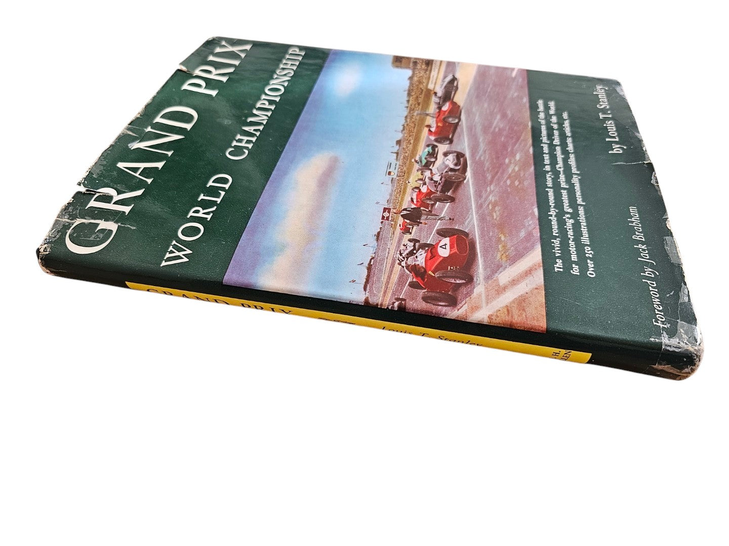 Vintage auto racing book with green and blue cover showing race cars on track.