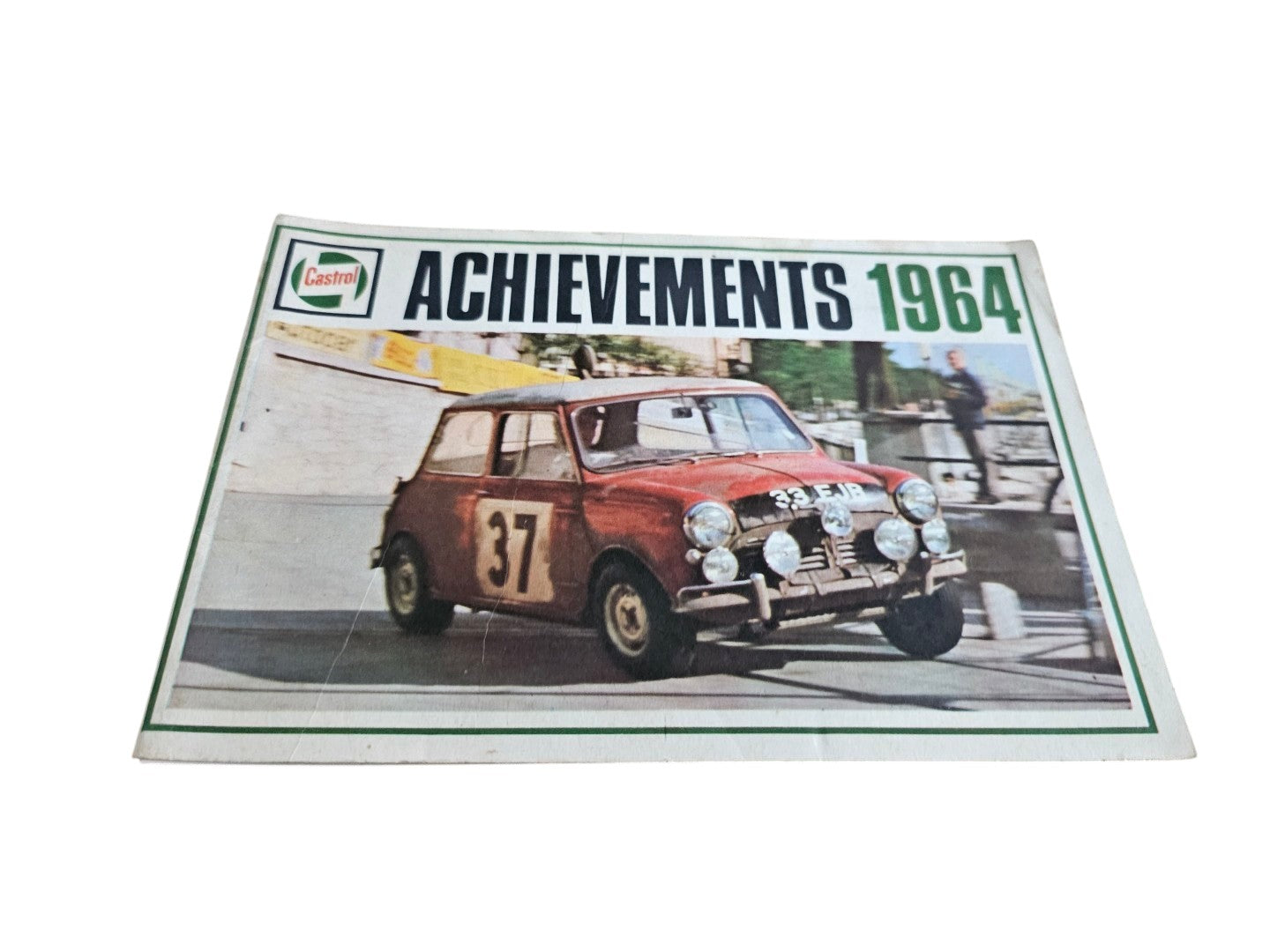 Vintage race achievements booklet cover with red Mini-style race car on an angled layout