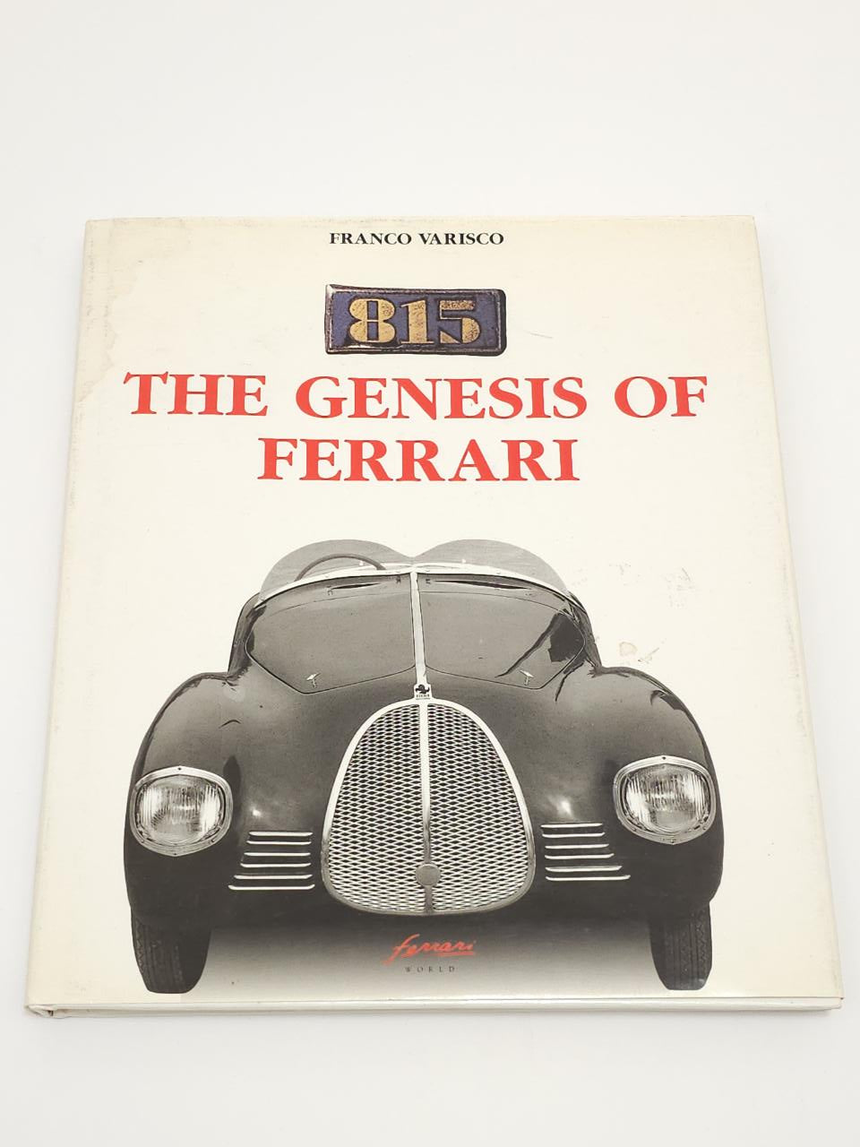 Hardcover book with 815 badge, The Genesis of Ferrari title, and front view of a black car