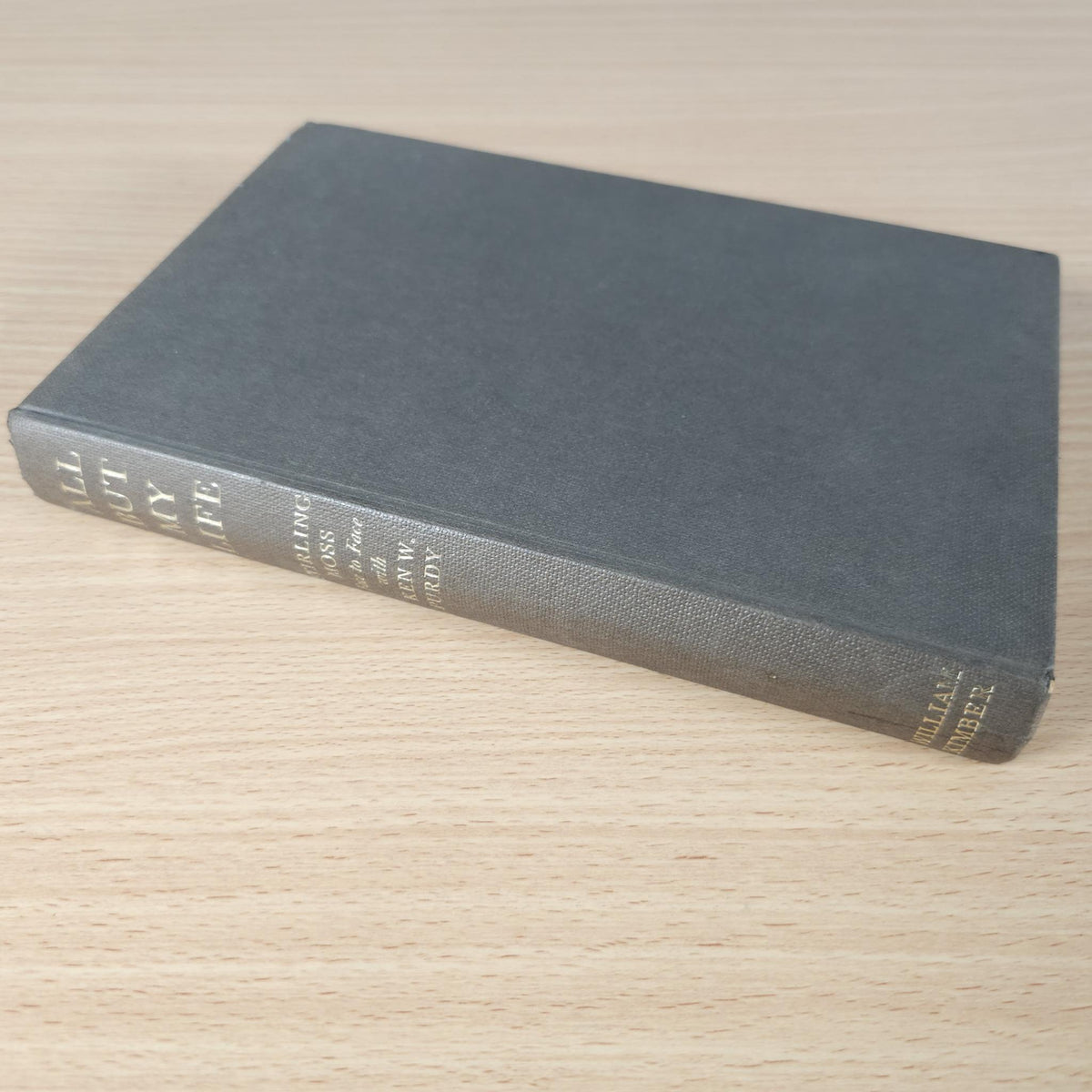 Hardcover book with dark blue cloth cover and spine text, lying on a wooden table
