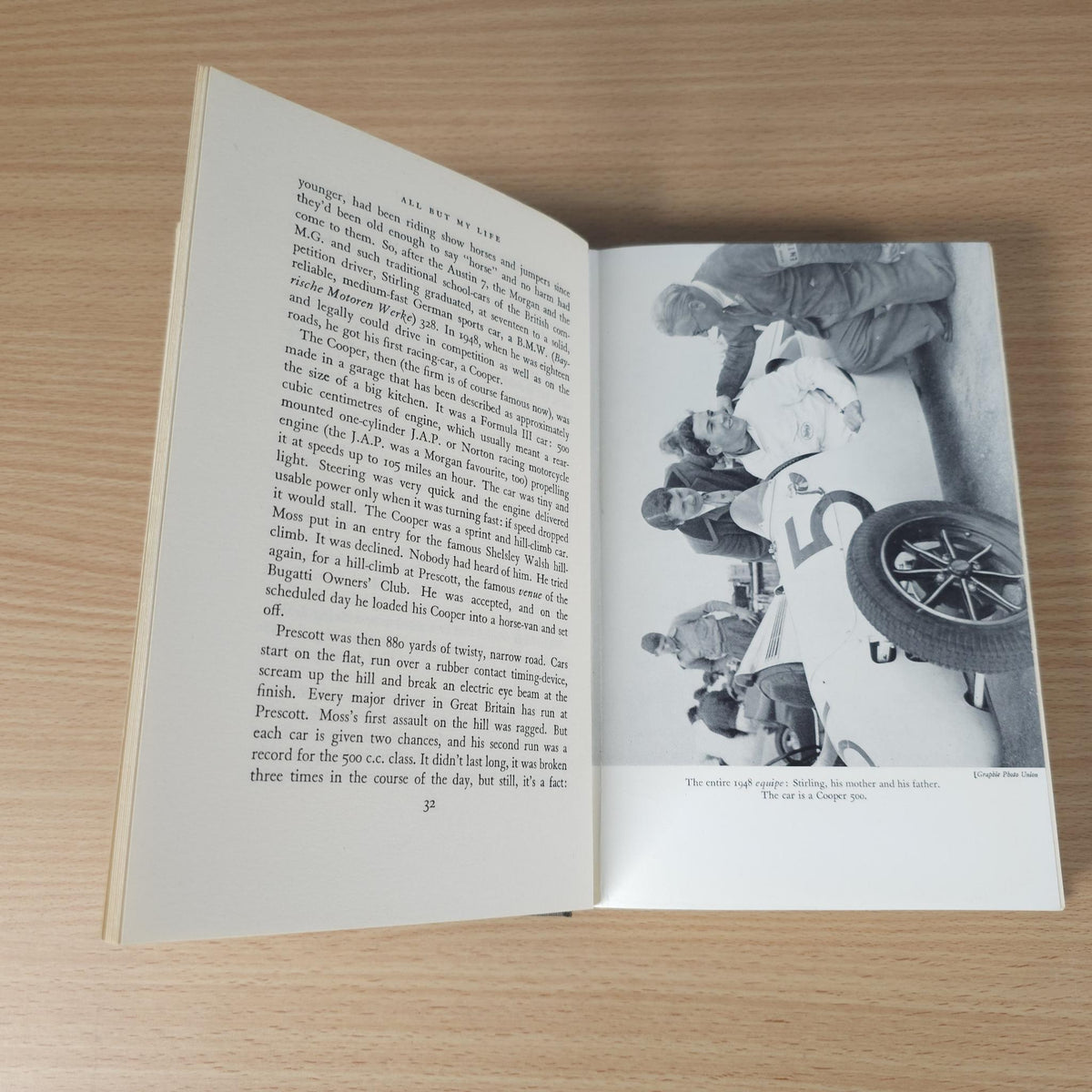 Open book with dense text and a black-and-white photo page featuring a racer
