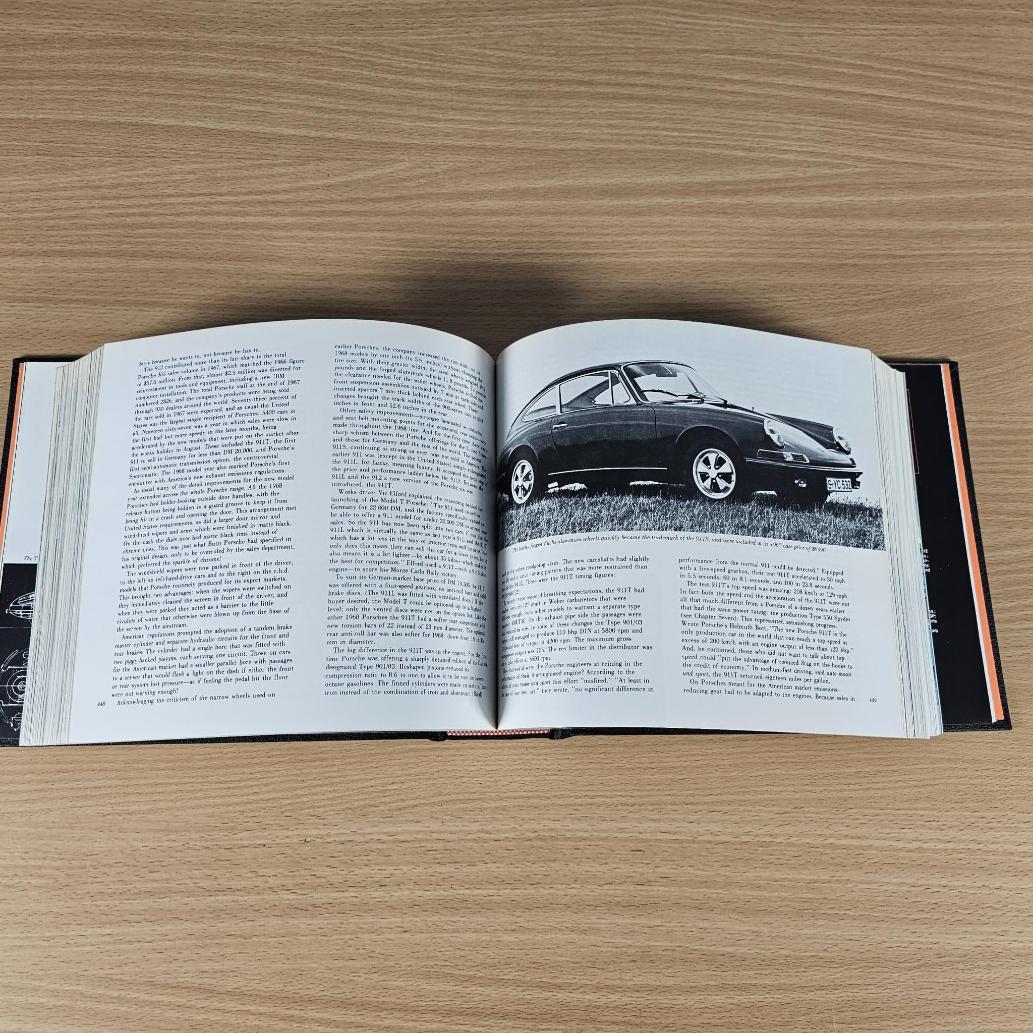 Open book with a black-and-white classic sports car photo and printed text pages.