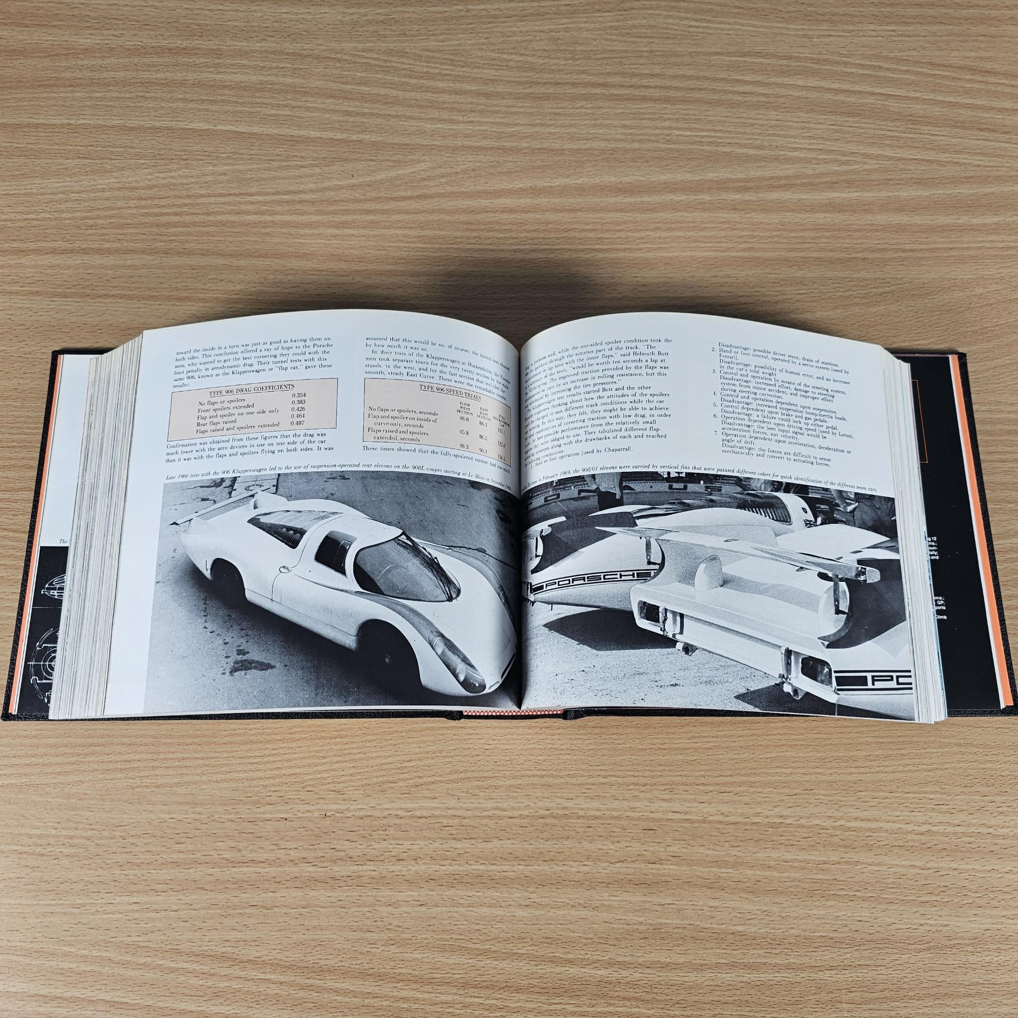 Open book showing black-and-white race car photos with captions and printed text.