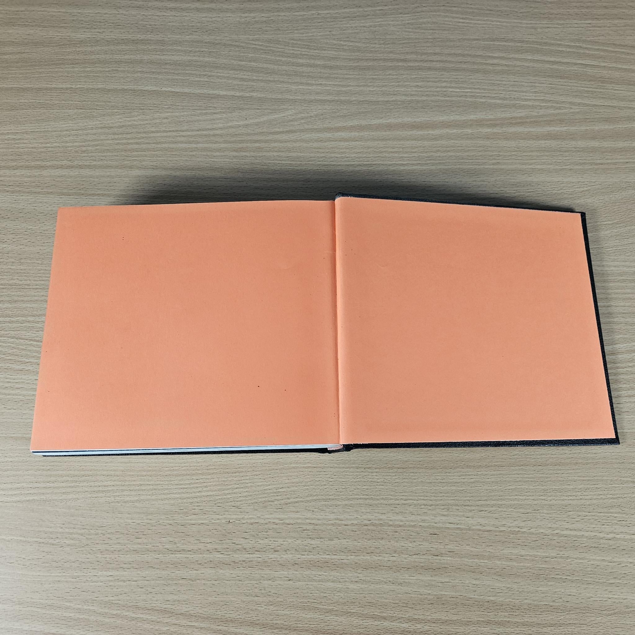 Open book with two peach-colored blank inside covers.